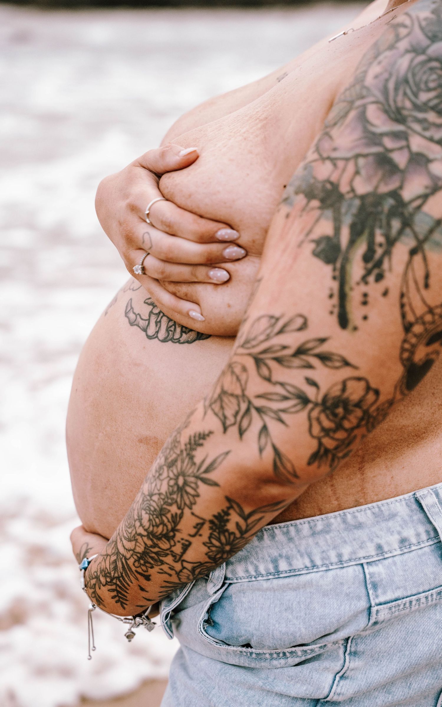 Close-up shots of tattooed skin and denim jeans showing floral and botanical ink designs in black and gray.