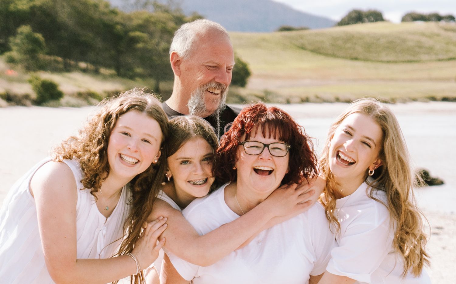 Joyful family portrait session outdoors with mountains and natural scenery.