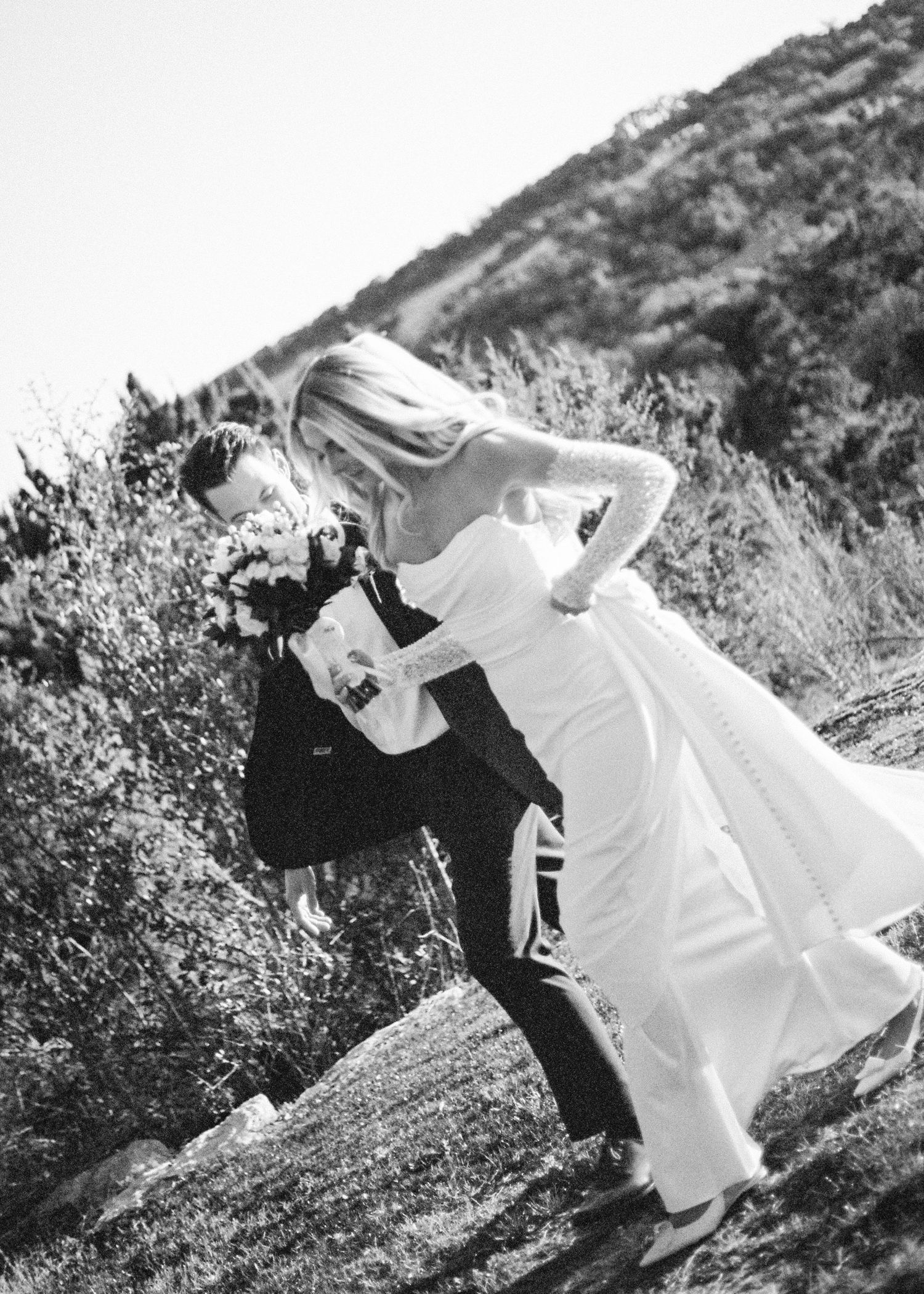 Documentary black and white photography of bride and groom walking from ceremony to reception in Austin, Texas