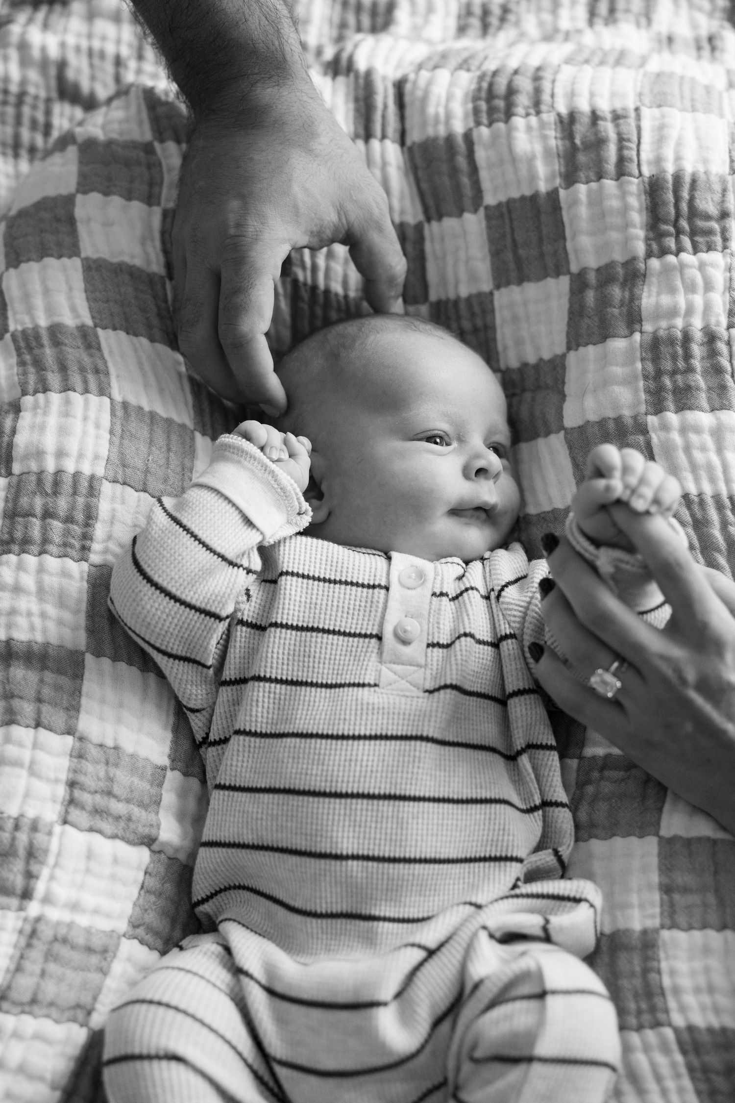 documentary newborn photograph with parents reaching for baby in Austin Texas