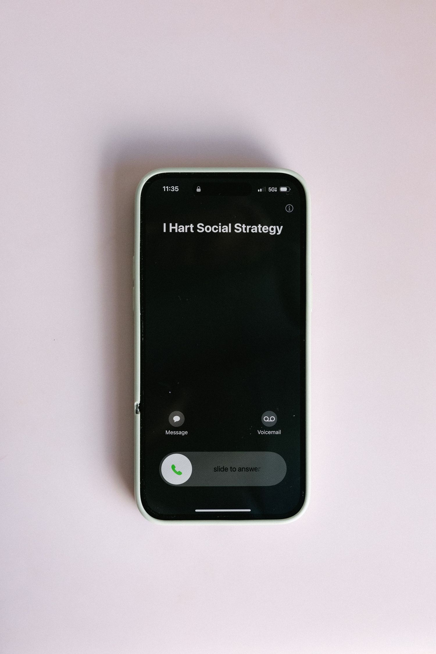 iPhone displaying incoming call from I Hart Social Strategy on white surface.
