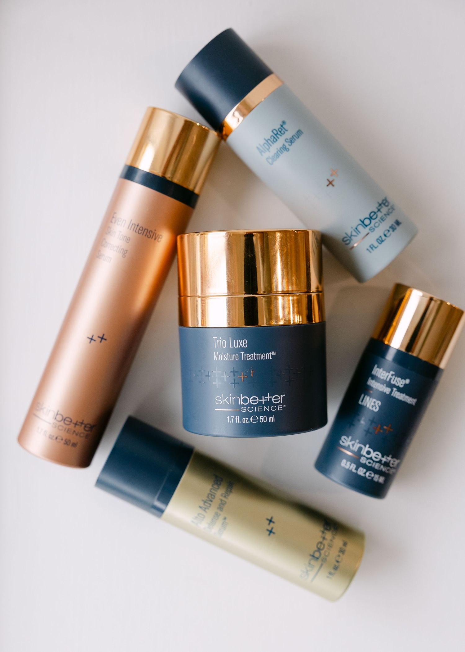 Skinbetter Science luxury skincare products arranged on white surface including moisturizer and serums.