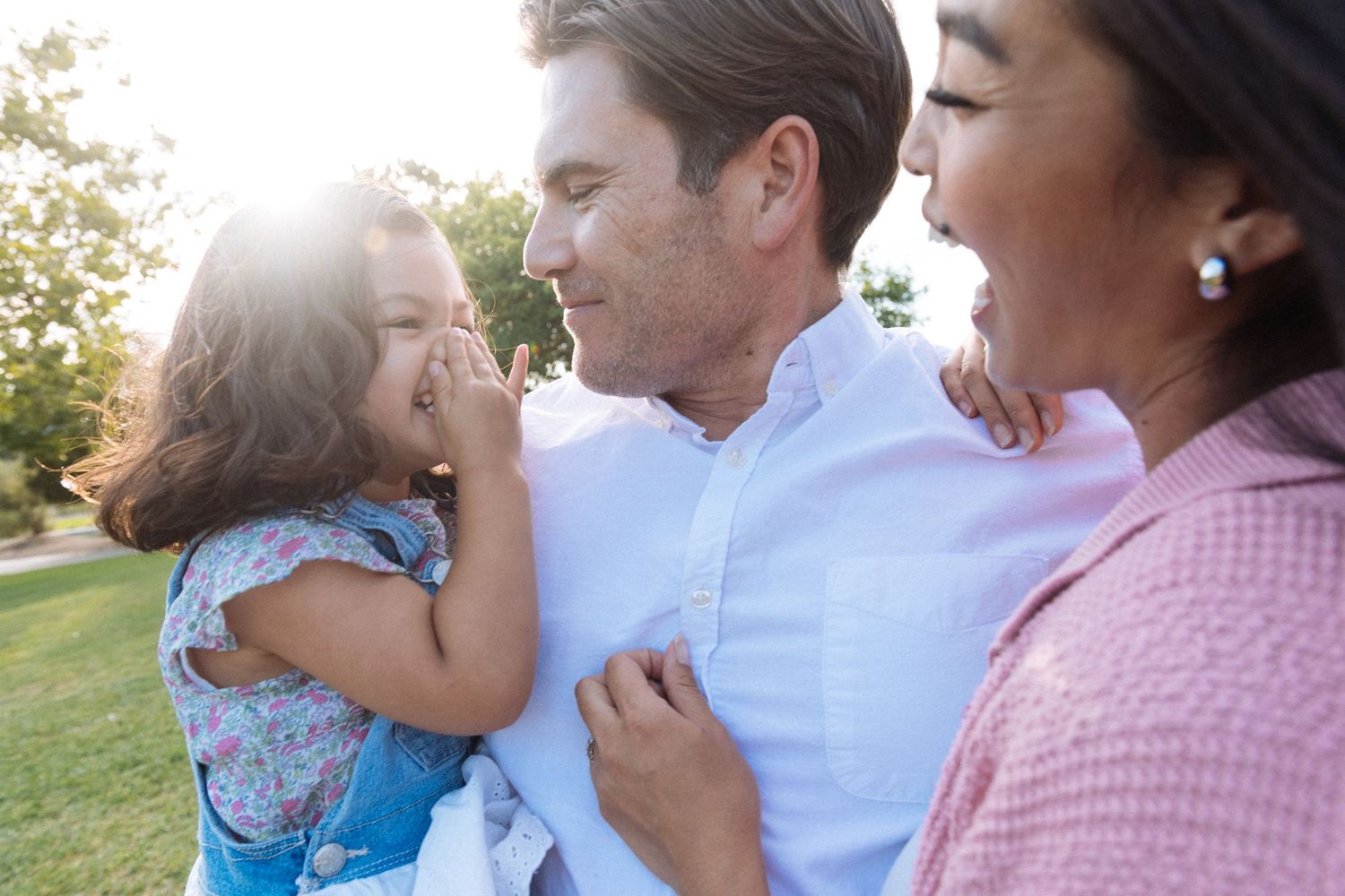 Family sharing intimate moments during an outdoor sunset photoshoot.