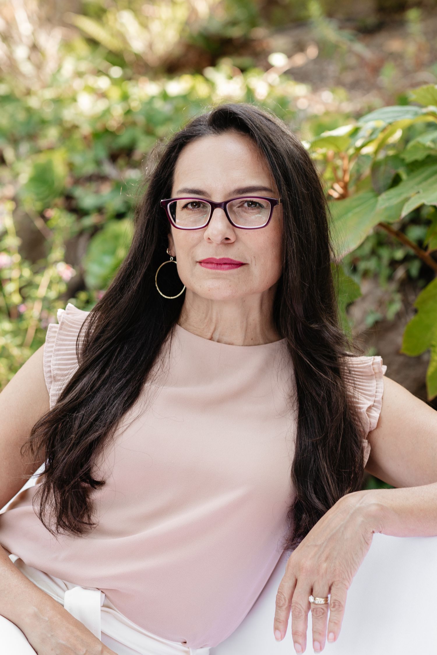 Outdoor portrait series featuring pink blouse and glasses against natural foliage background.