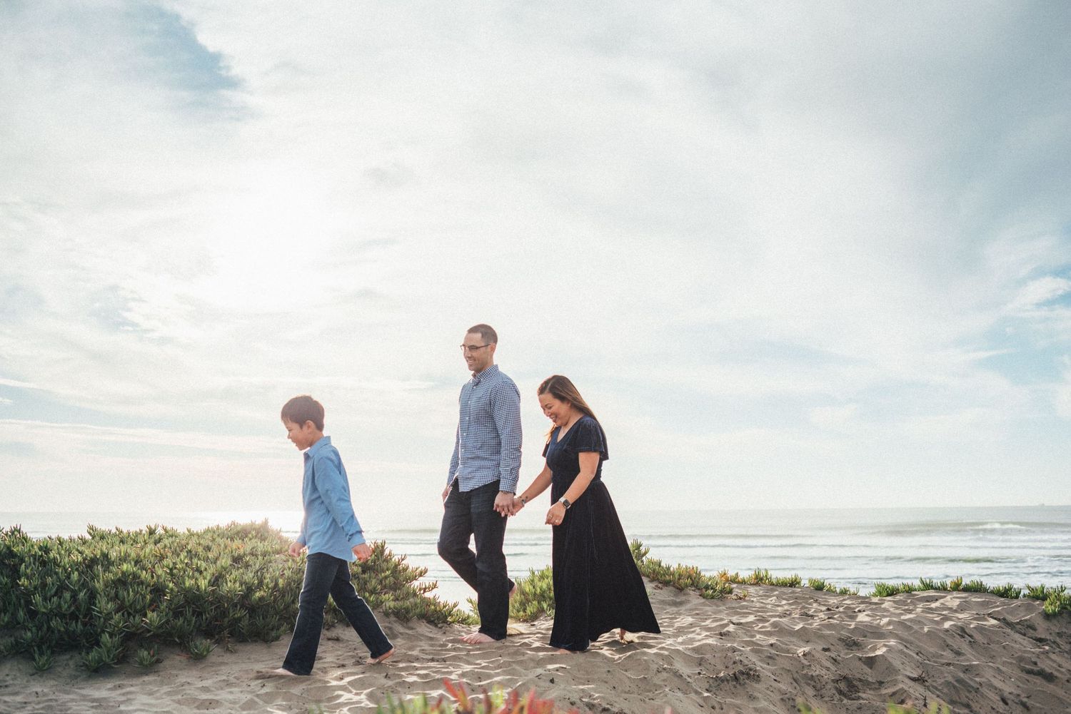 People stroll together on a coastal path with ocean views.