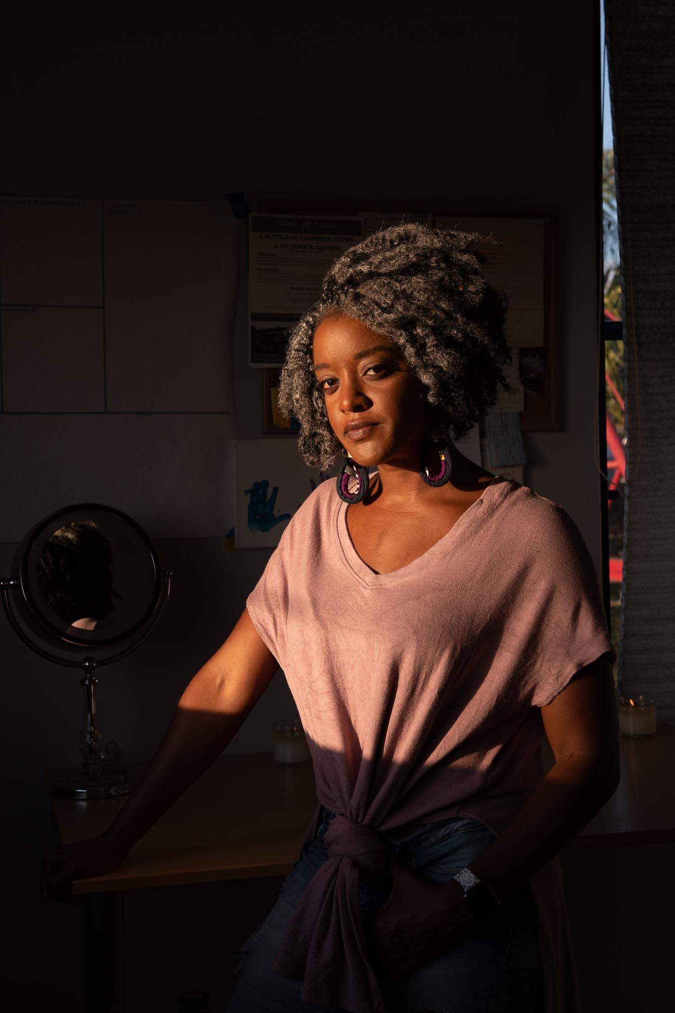 Artistic portrait series in moody lighting showing person in pink top against dark background.
