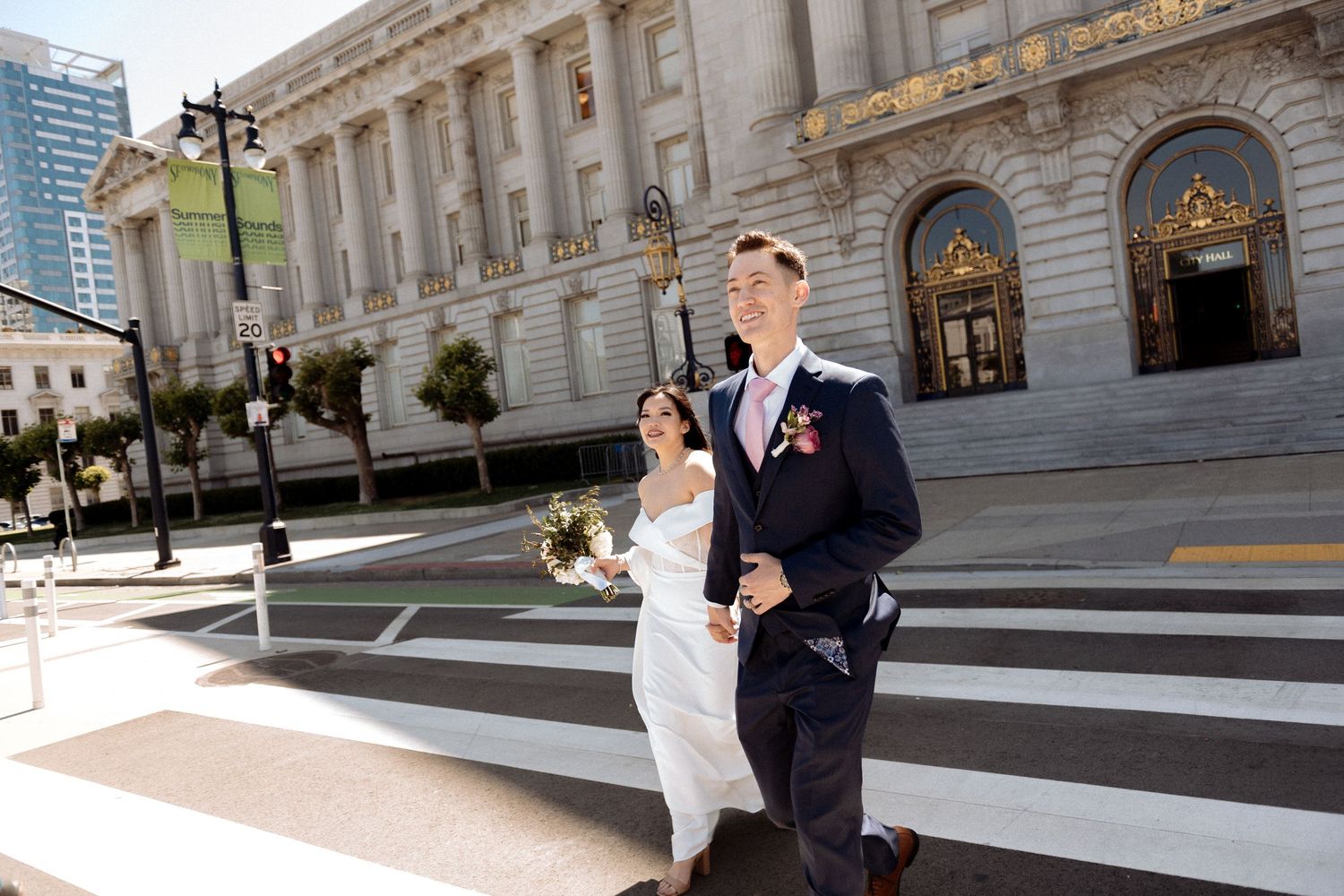 A bride and groom share a romantic moment on the grand steps of a historic stone courthouse building.
