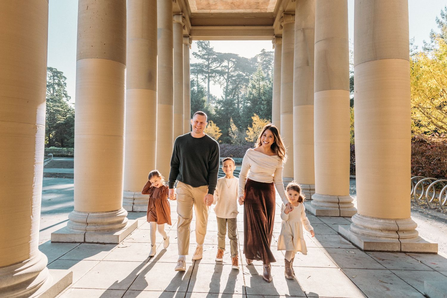 Sunlight streams through classical columns creating dramatic shadows and silhouettes.