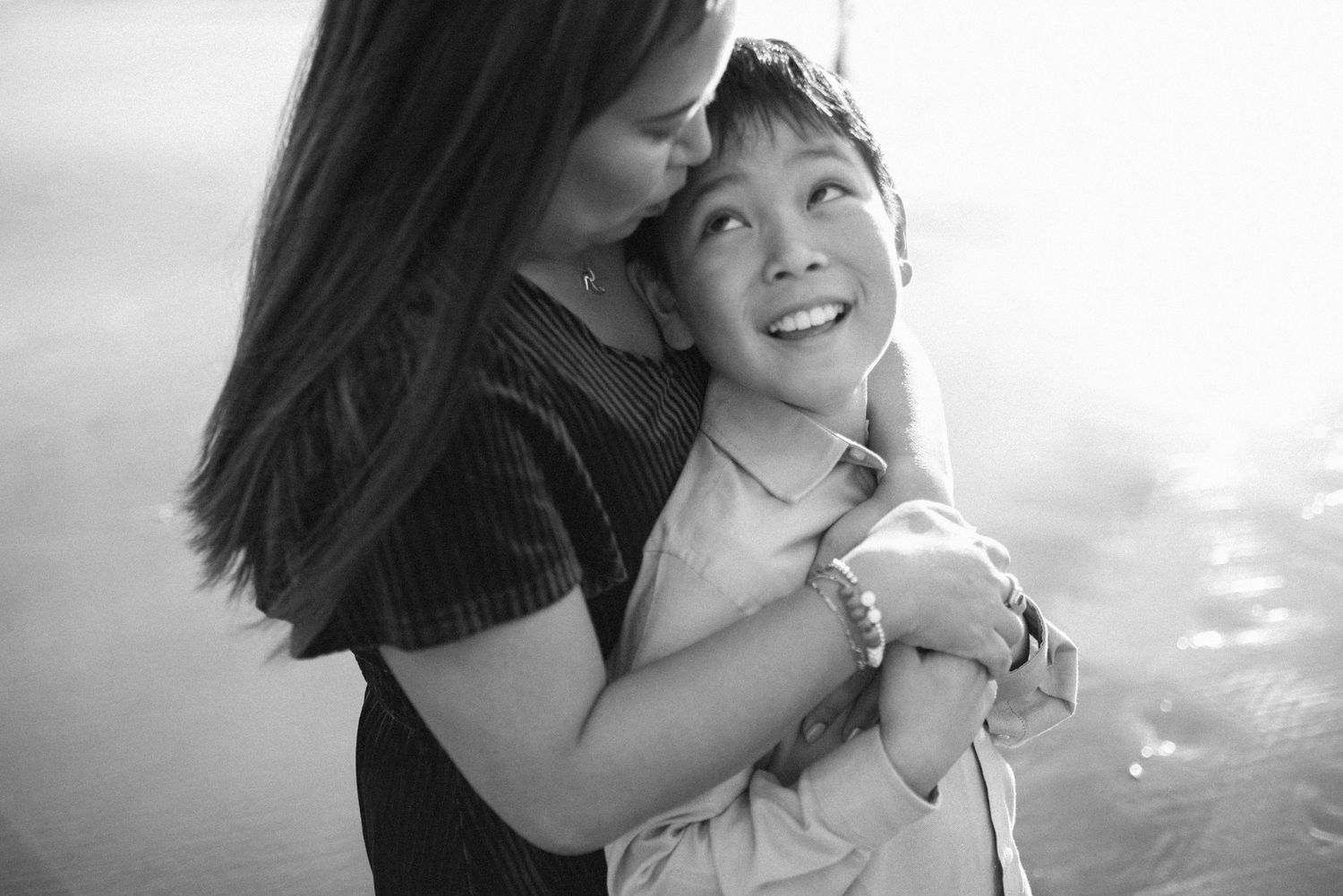 A couple laughs together during an outdoor photoshoot with natural lighting.
