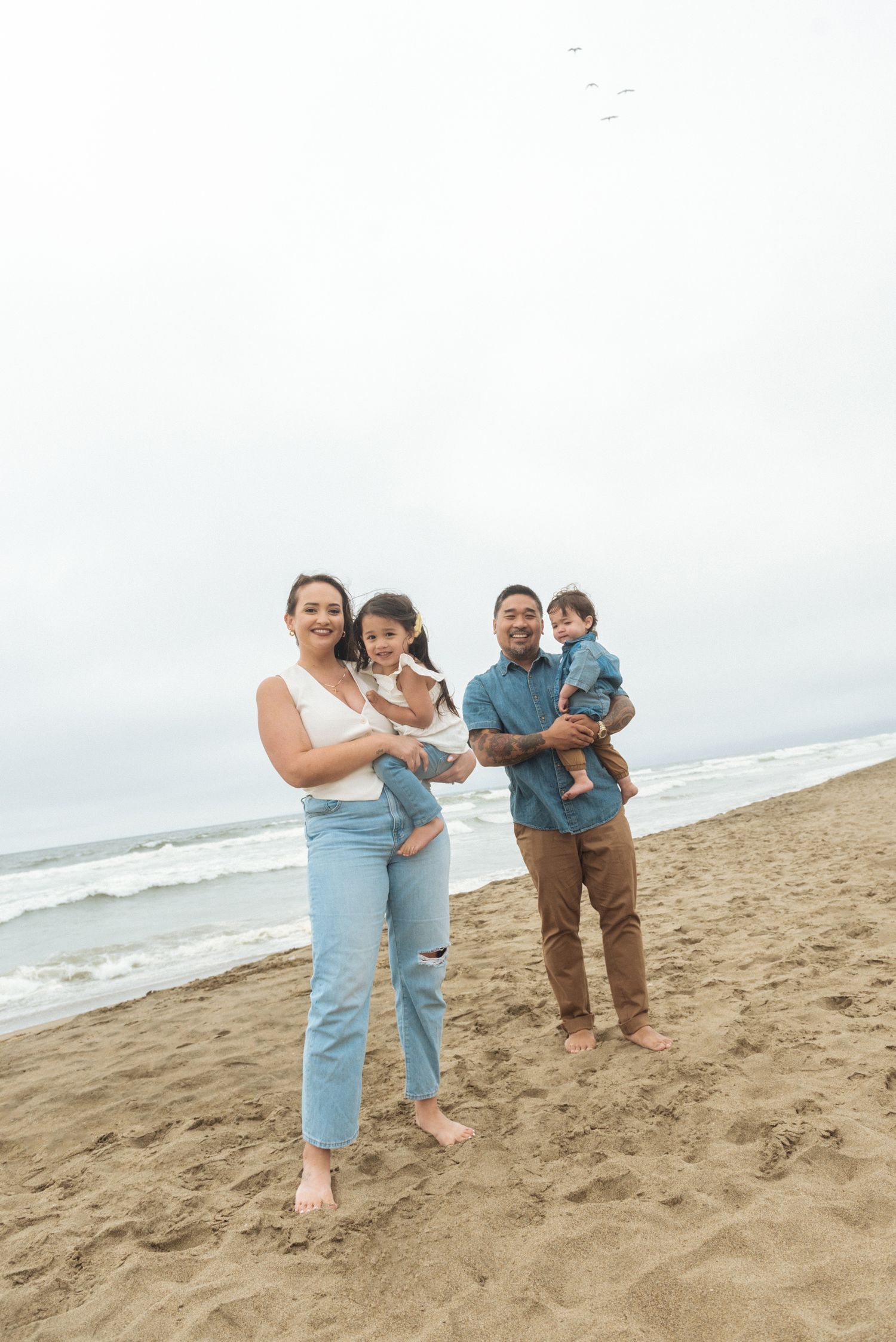 Family enjoying a relaxed day together on a sandy beach by the ocean.