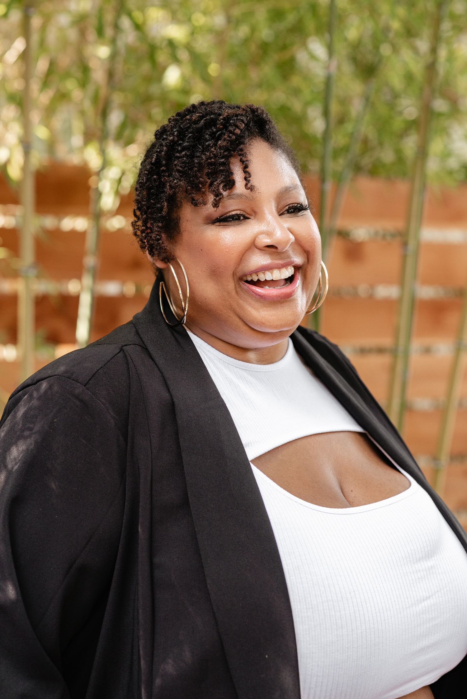 Professional portraits showing joyful expressions while wearing a black blazer and white top.