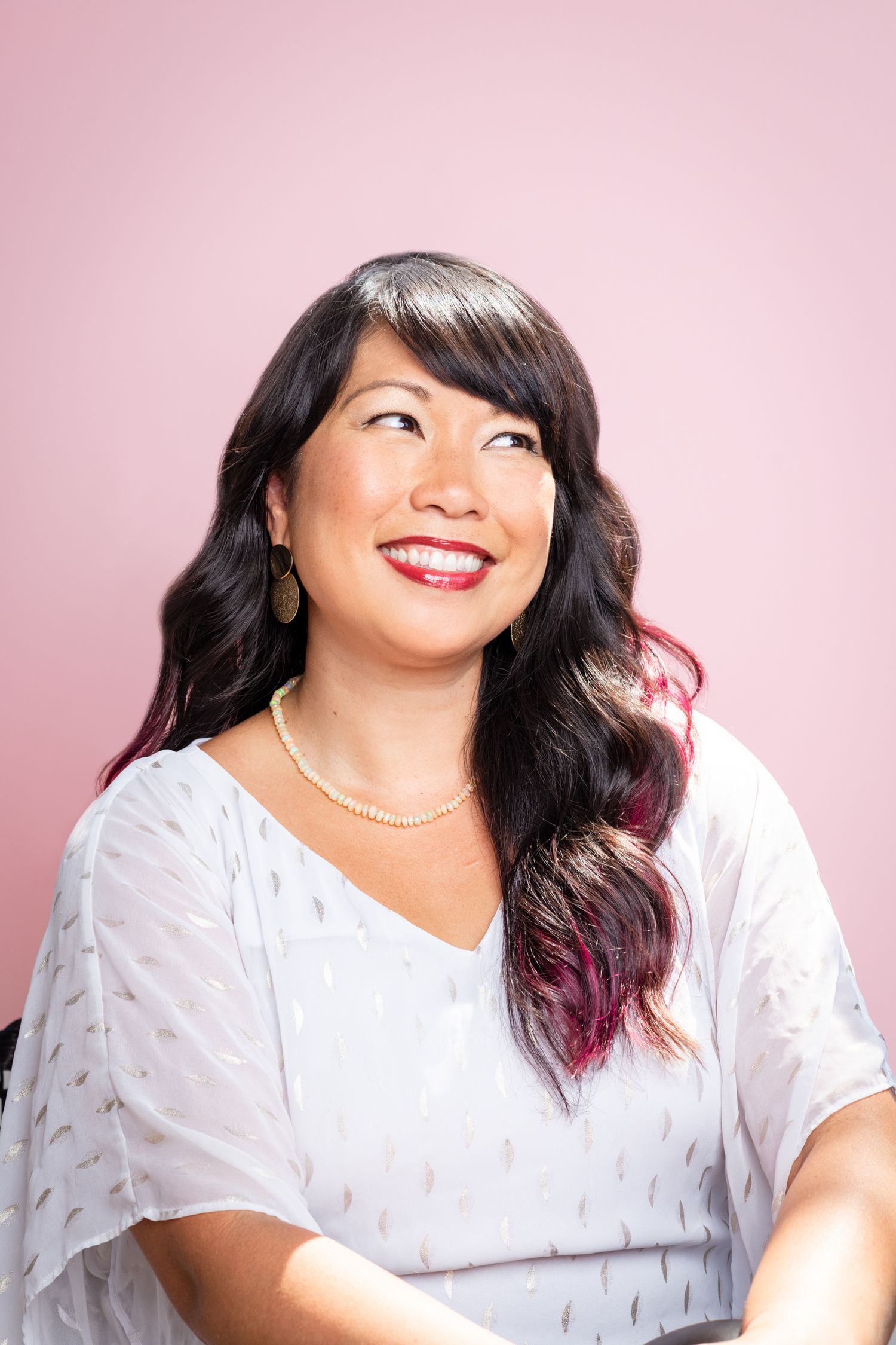 Casual portrait series in white top against soft pink background.