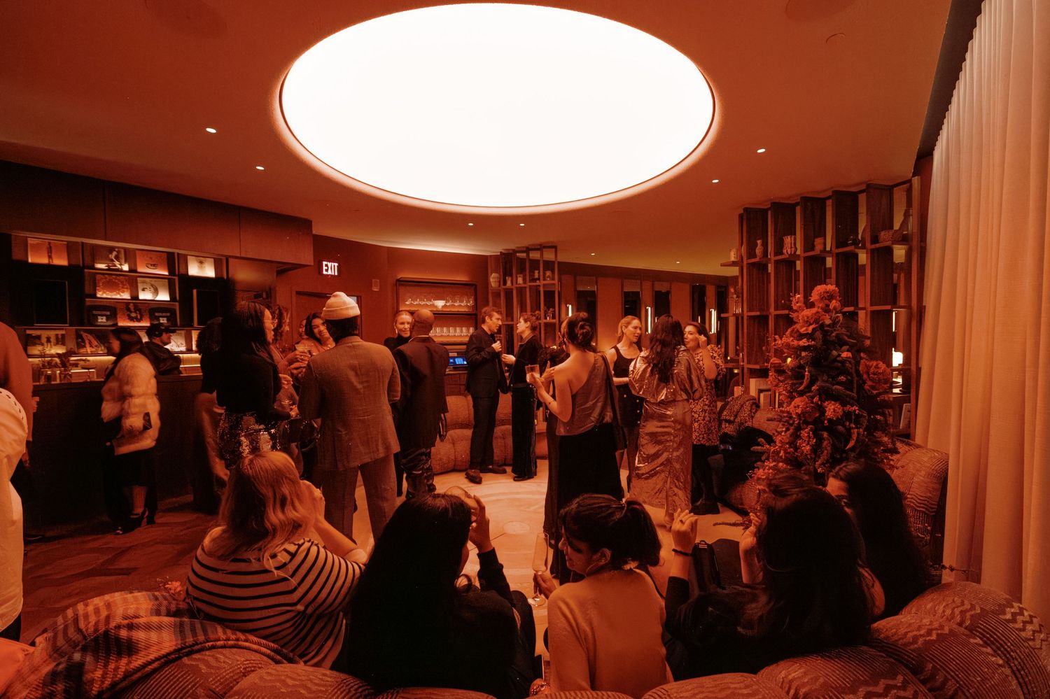 A crowded restaurant interior with warm lighting and multiple dining tables filled with patrons enjoying their meals.