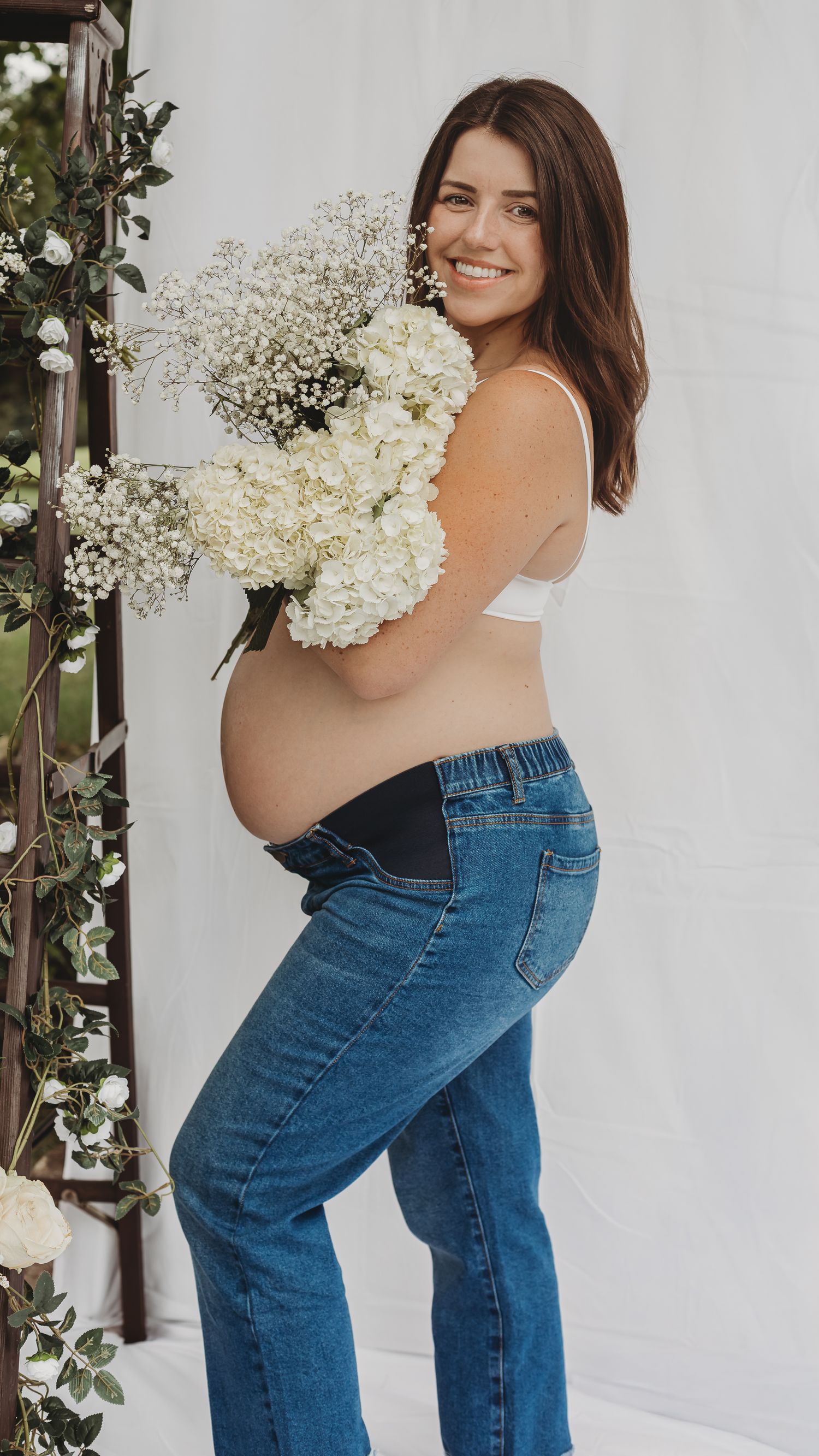 Woman holding a bouquet of white flowers during a natural portrait photography session in Maryland.