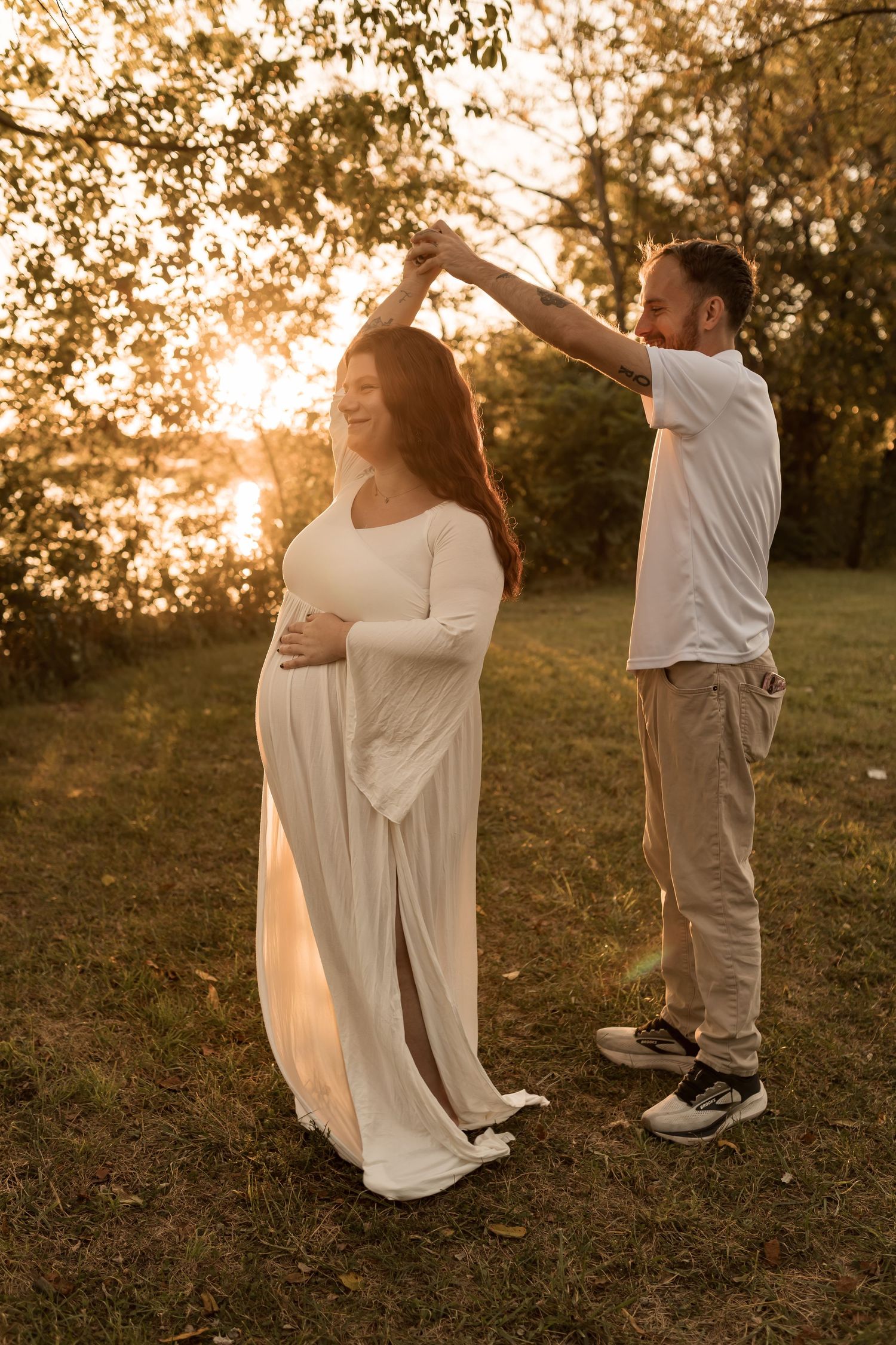 Couple embracing during a romantic outdoor maternity photography session at sunset in Maryland.