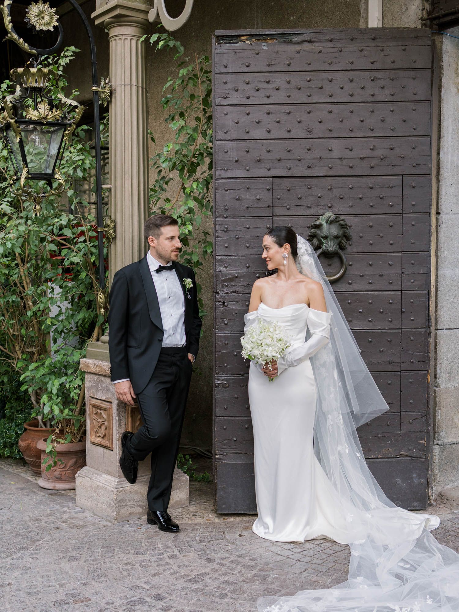Couple leaning on doorway at Castello di Tor Crescenza, Rome, post-ceremony editorial shoot.