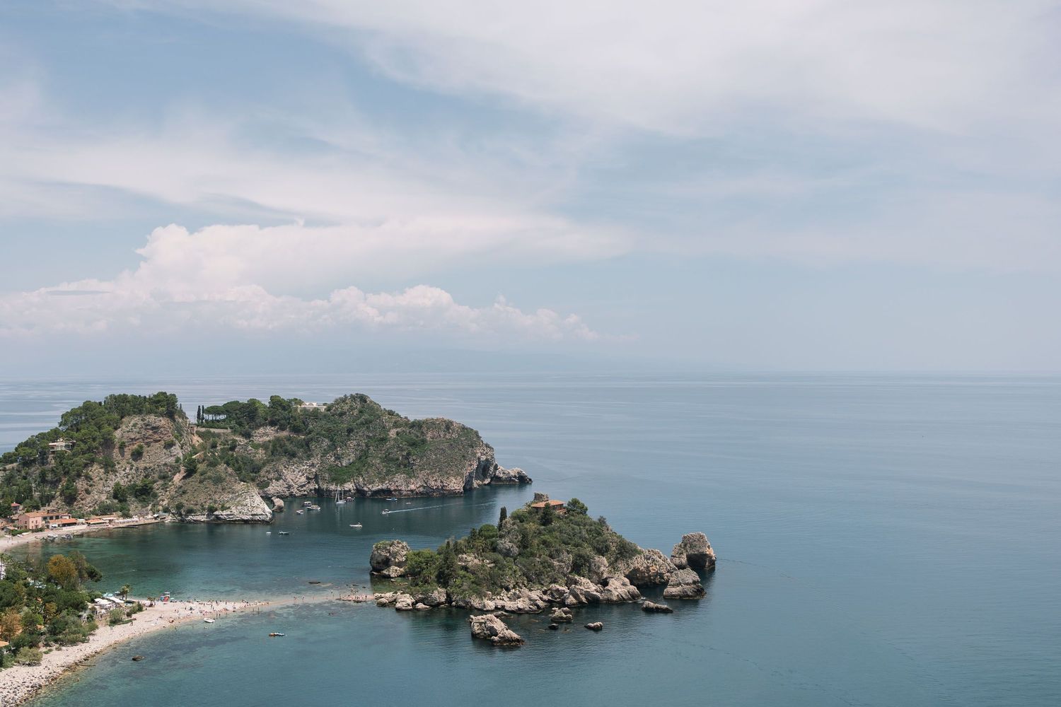Aerial view of Isola Bella island and beach in Taormina, Sicily, with turquoise Mediterranean waters and rocky coastline.