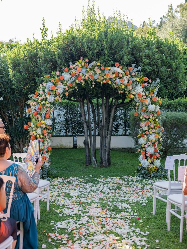 Garden wedding setup at Villa Mon Repos in Taormina, Sicily, with guests seated and floral arch decoration.