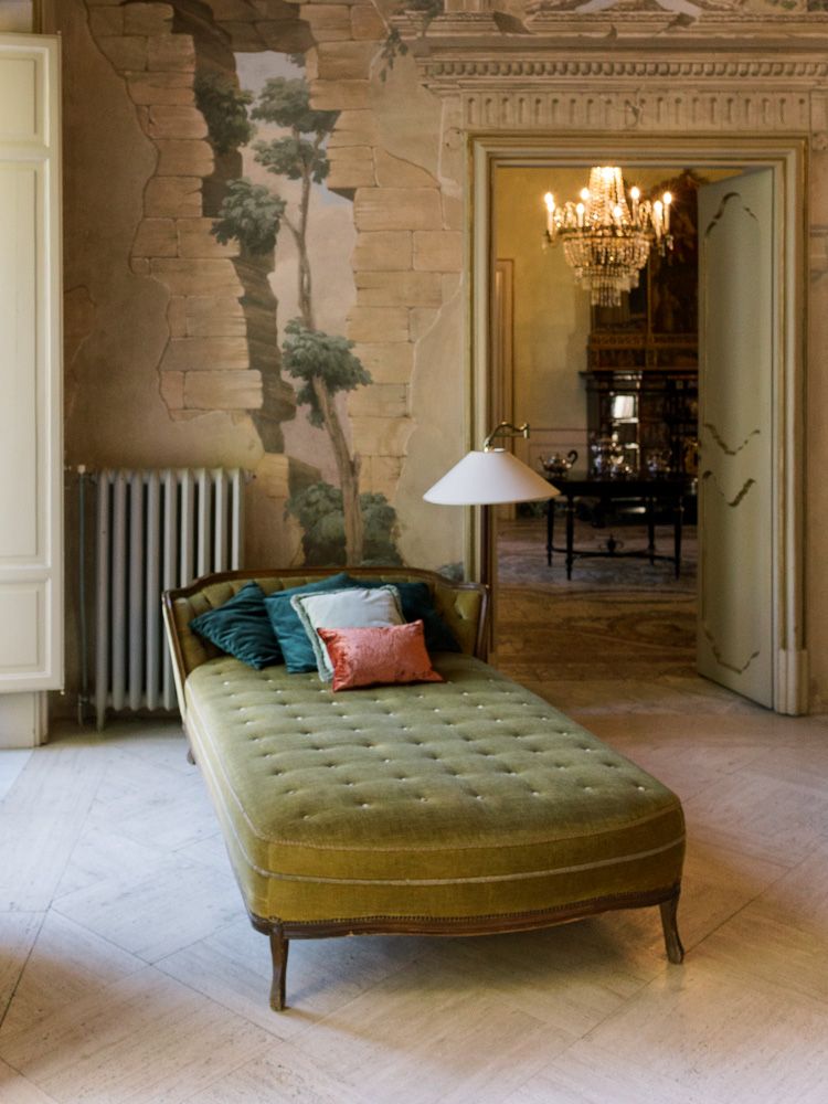 Luxury interior of Villa Tasca in Sicily with elegant furniture and sunlight coming through open balcony doors.
