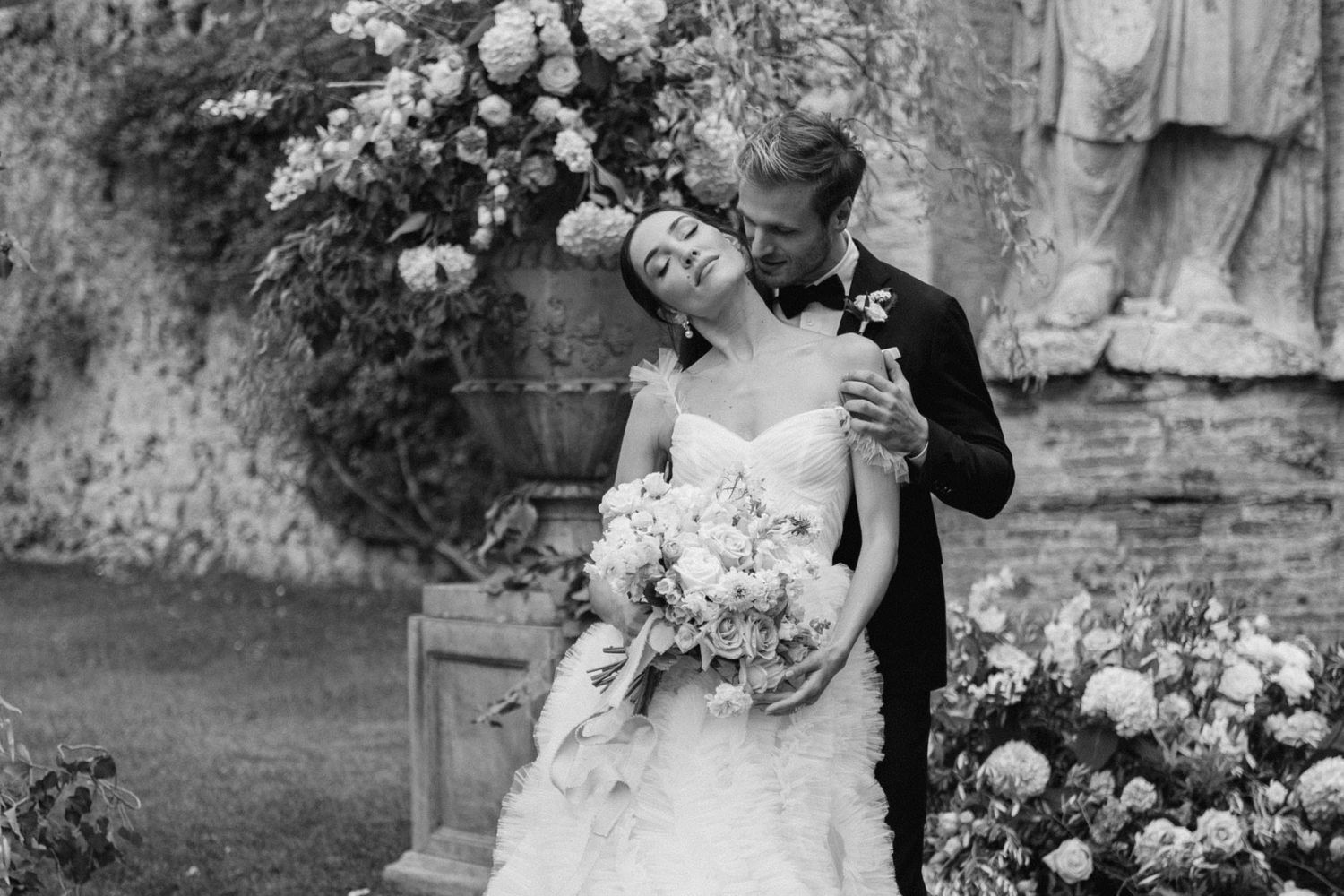 Romantic couple portrait at Villa Cetinale in Tuscany, groom kissing the bride’s neck during an elegant destination wedding in Italy.