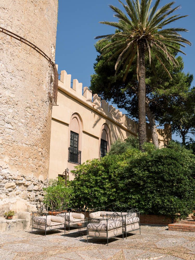 Historic exterior of Castello di Trabia with balconies and tower, perfect for destination wedding photography.