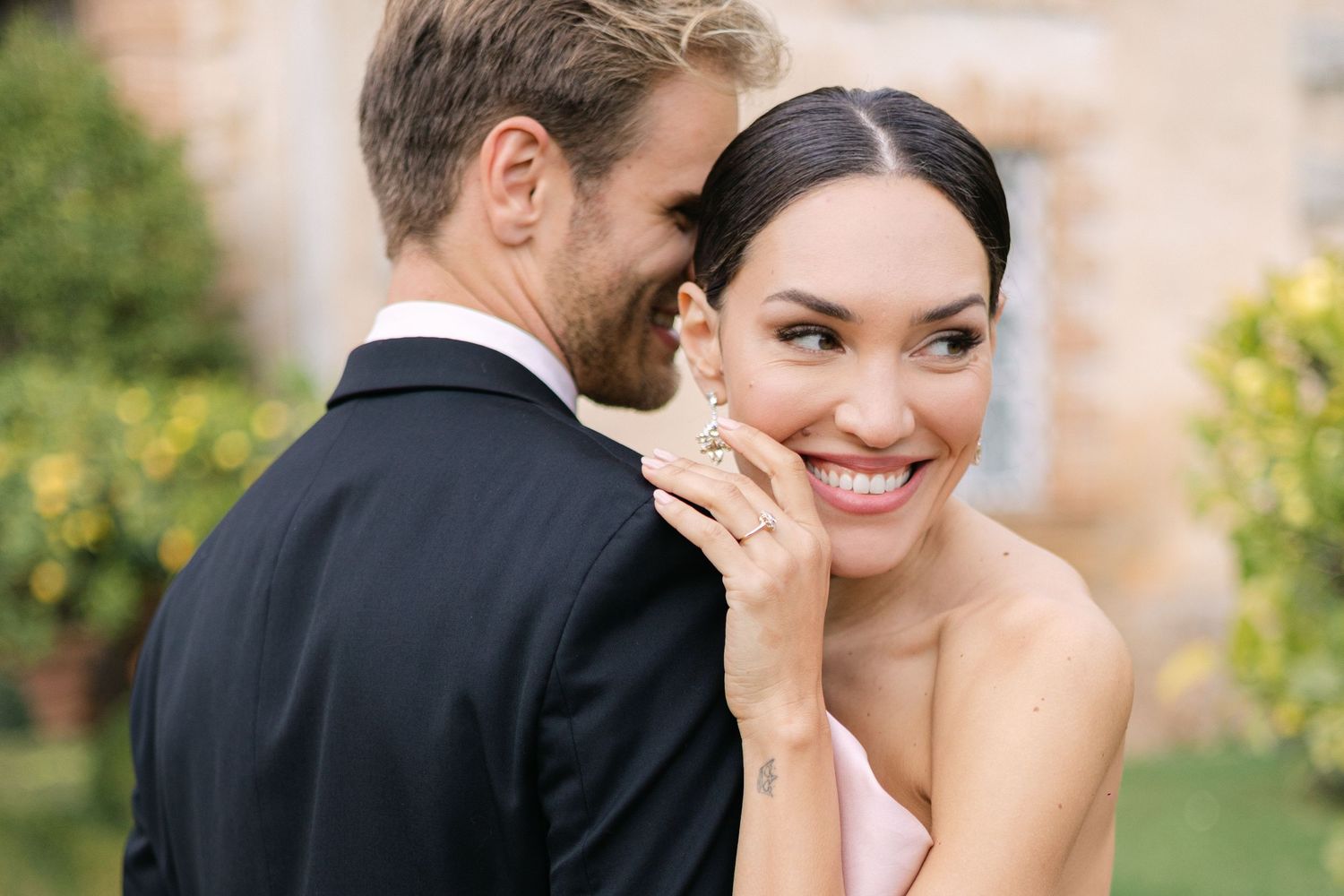 Romantic proposal moment in Taormina, Sicily, with the bride-to-be embracing her partner in a lush green setting.