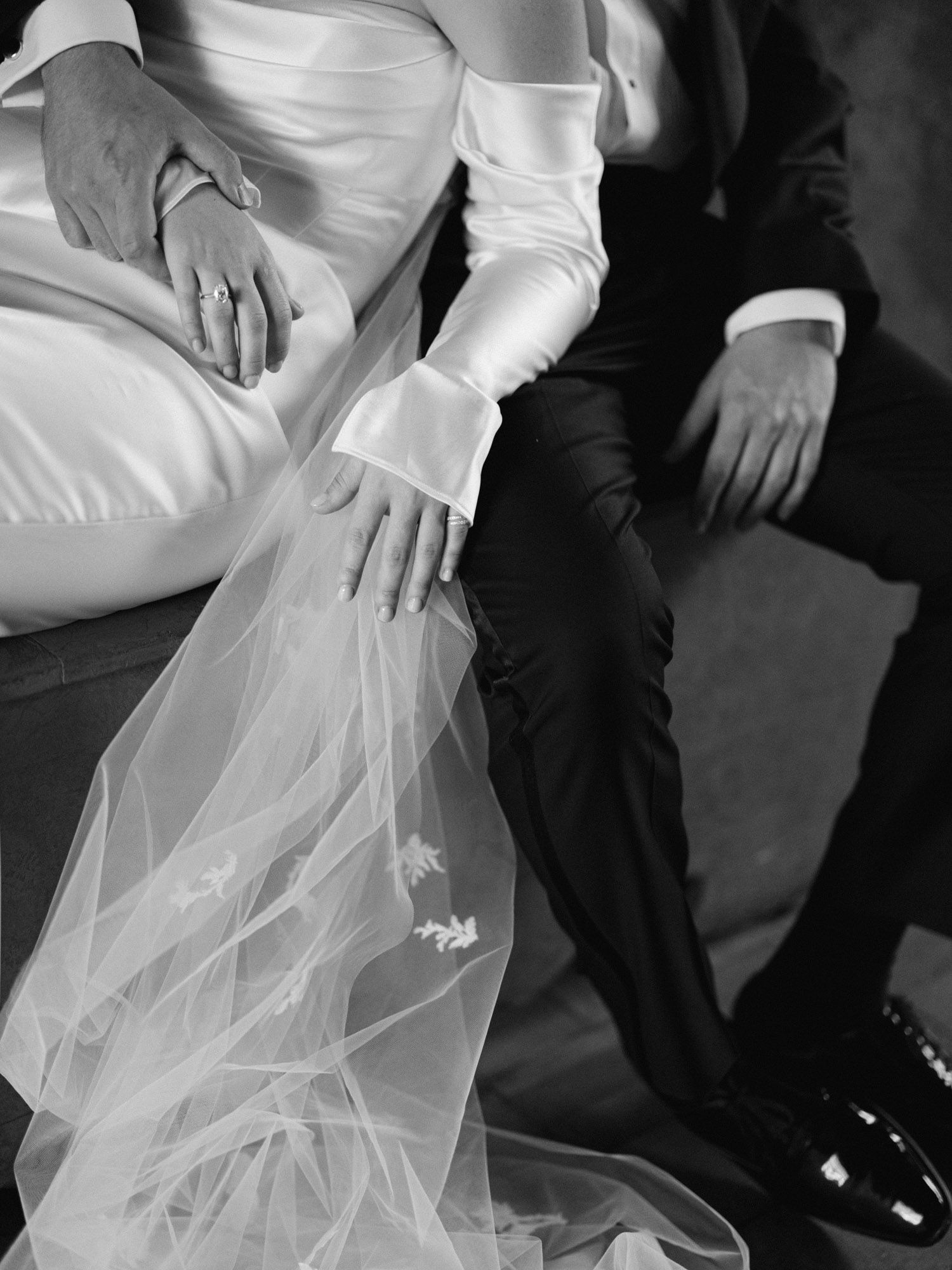 Close-up of bride and groom hands, veil and legs at Castello di Tor Crescenza, Rome.