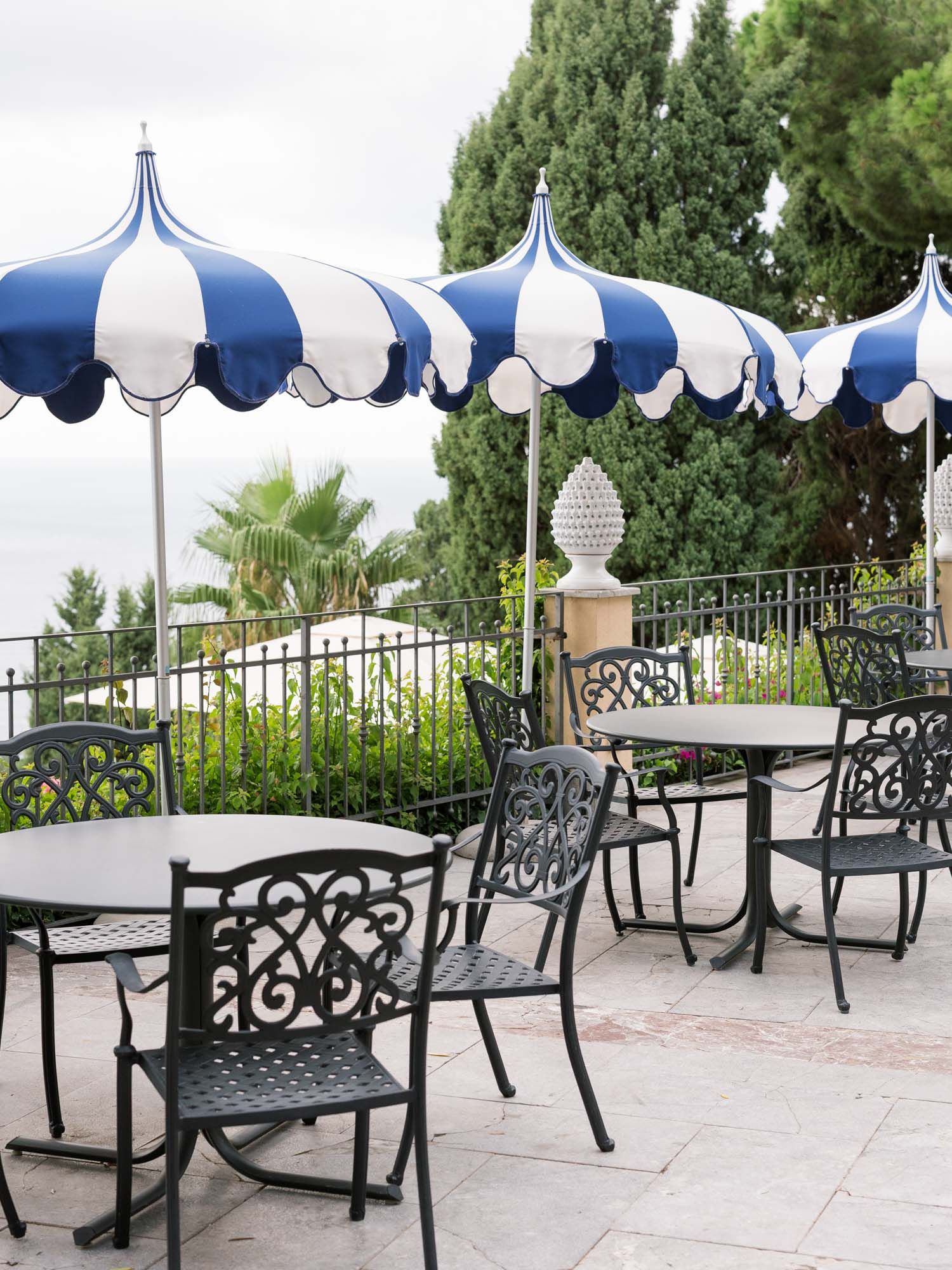 Balcony setup with umbrellas and tables at Hotel San Pietro, Taormina, romantic proposal setting.