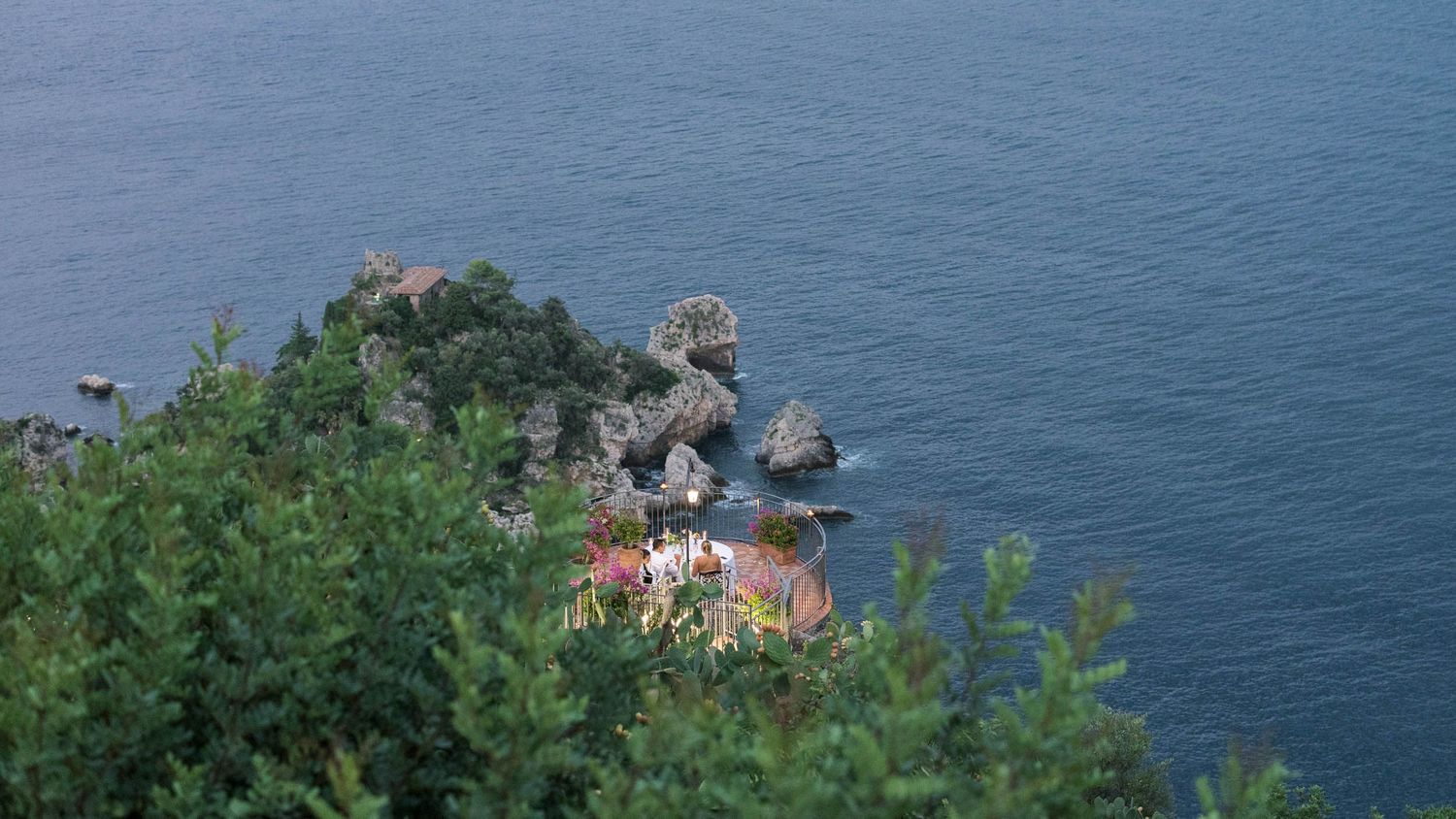 Couple dining by candlelight on balcony at Hotel San Pietro, Taormina, romantic proposal.