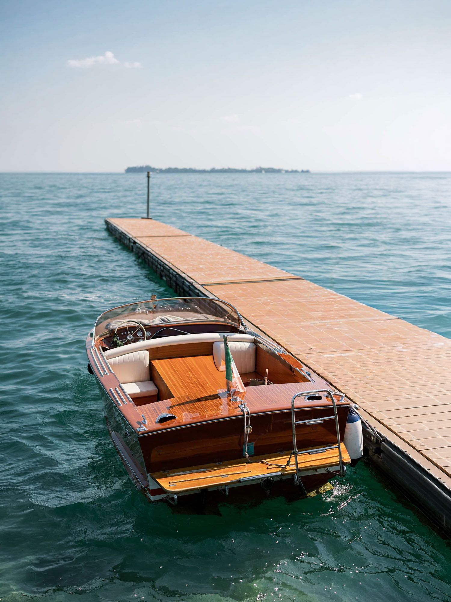 Wooden boat at Isola del Garda, used for couple transport and editorial wedding shoots.