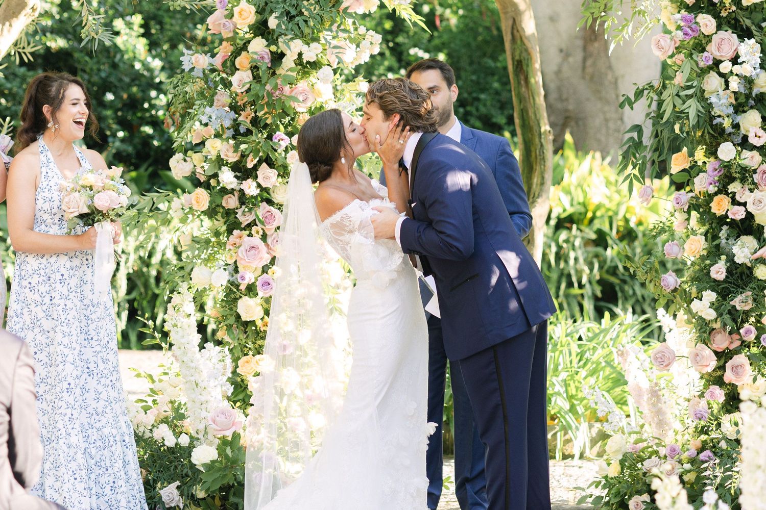 Beautiful outdoor wedding ceremony under floral arch with delicate white and pink blooms in lush garden setting. Wedding in Sorrento.