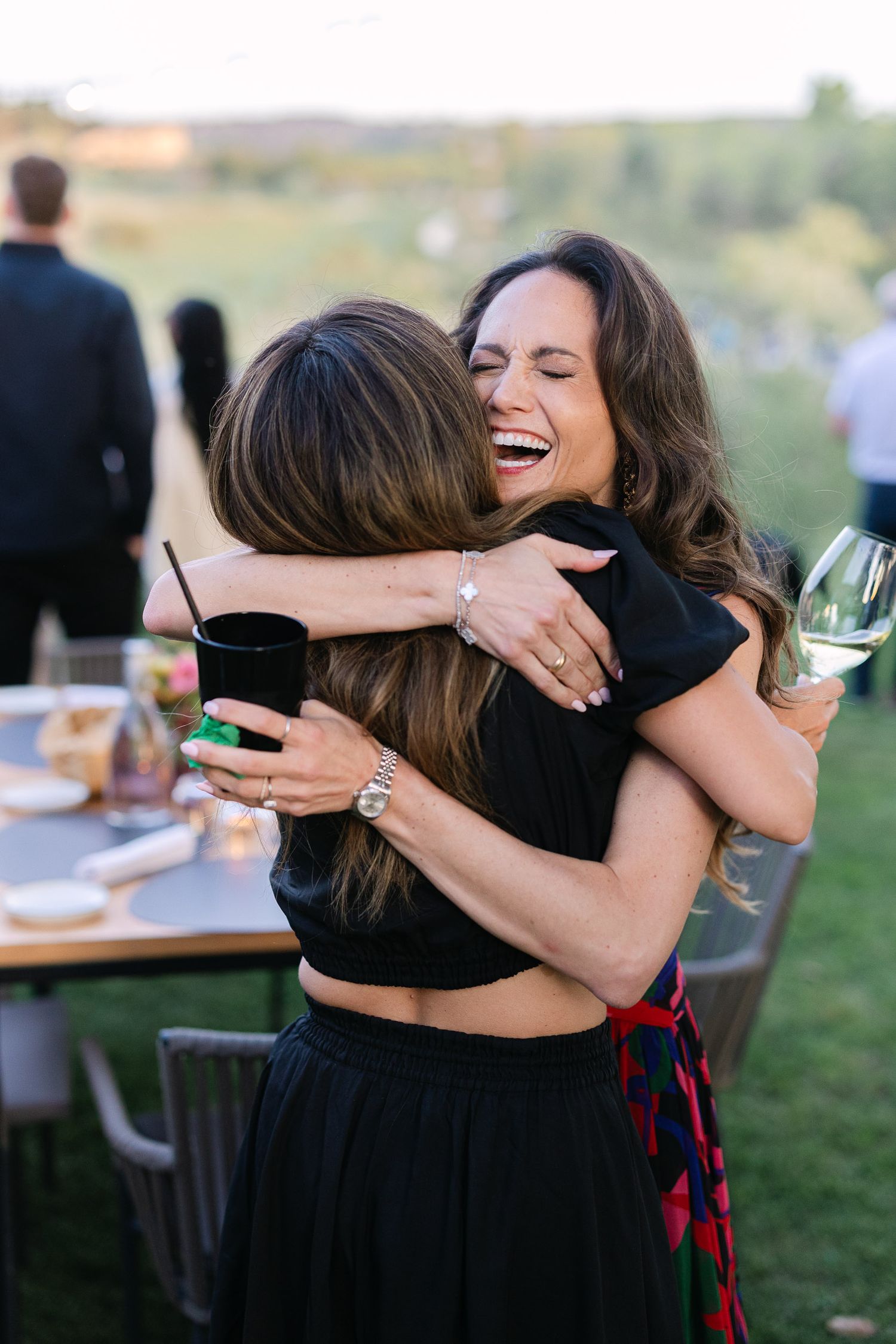 Emotional candid photo of guests embracing at a luxury destination wedding in Sicily, surrounded by warm Mediterranean atmosphere.