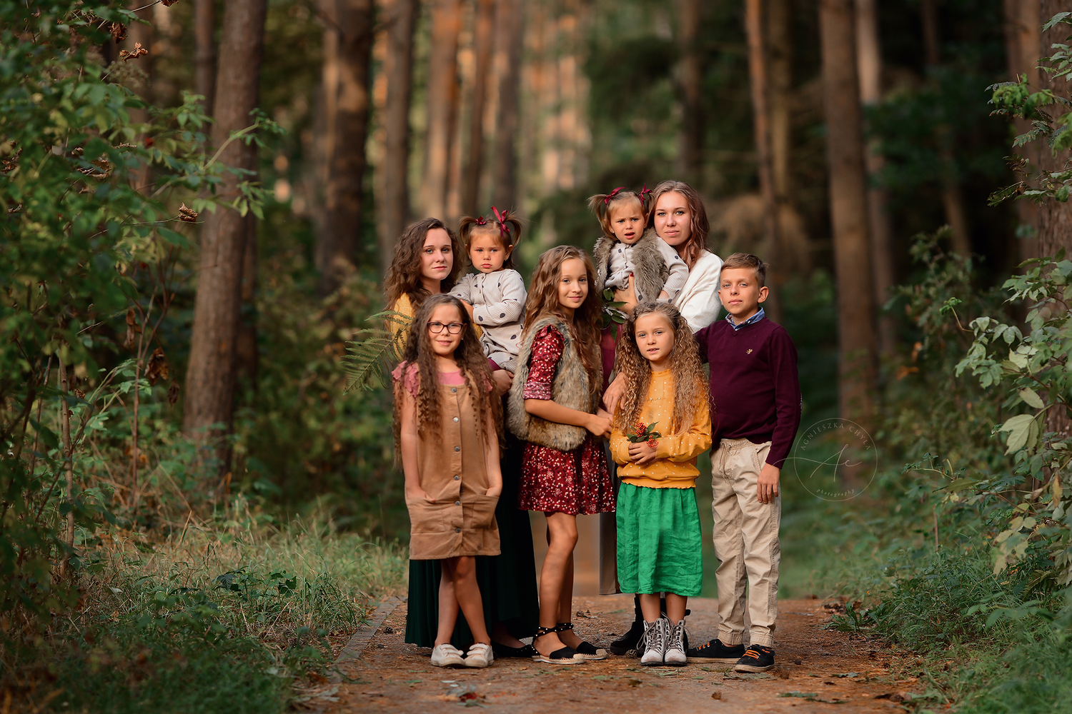 Group of eight children posing together on a forest path among tall pine trees. Family and group photography Toronto