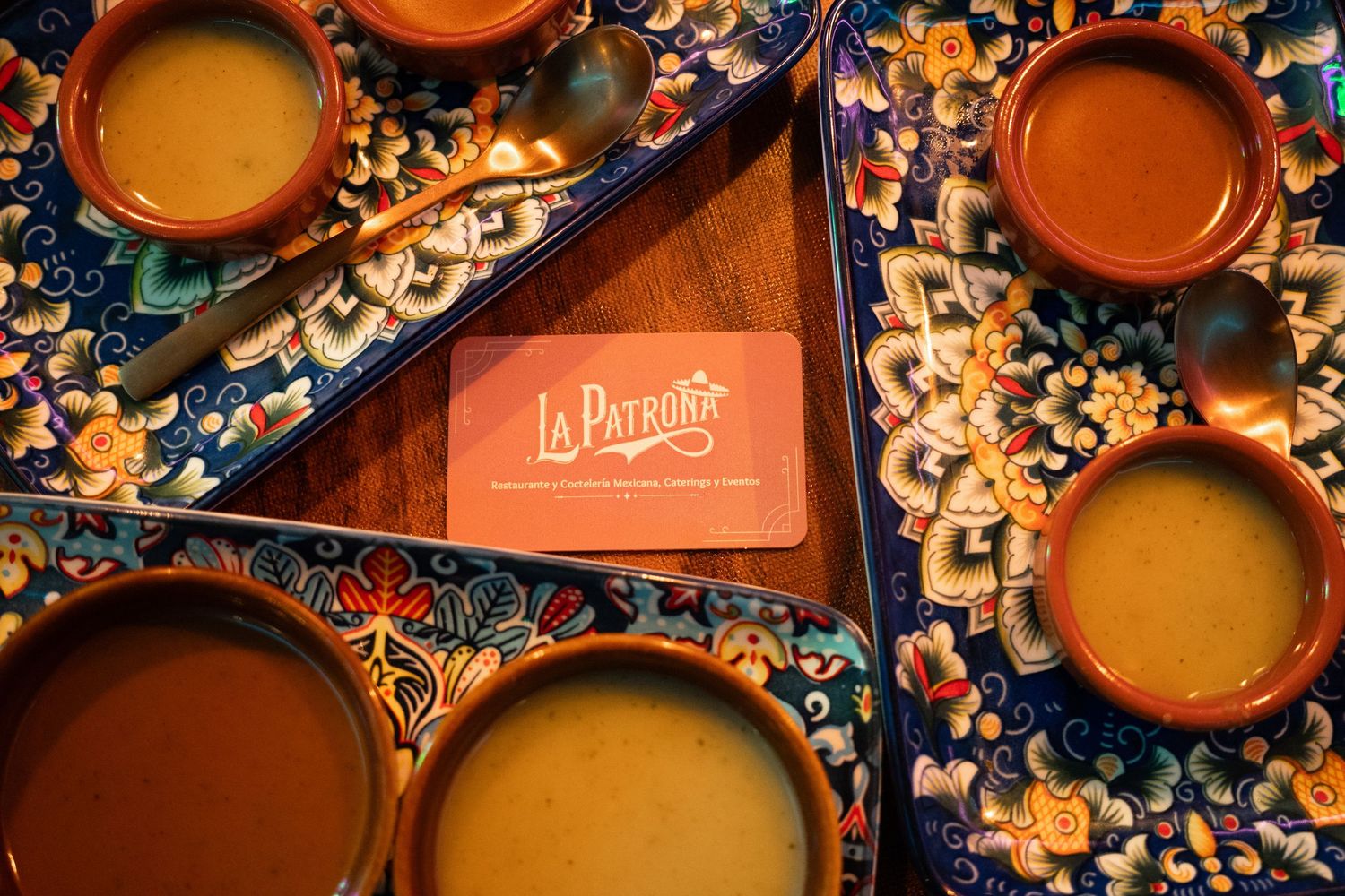 Vista cenital de una bandeja con cuatro salsas mexicanas auténticas y el logo central de Restaurante La Patrona. Fotografía gastronómica.