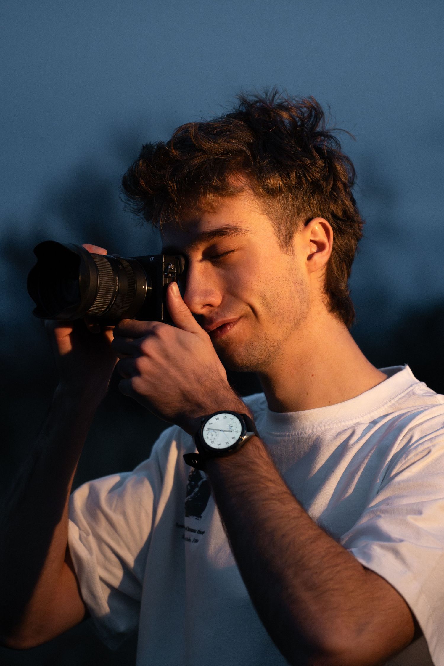 Retrato del fotógrafo Guillermo ARW trabajando con su cámara durante el atardecer. Fotografía profesional con luz natural en Málaga
