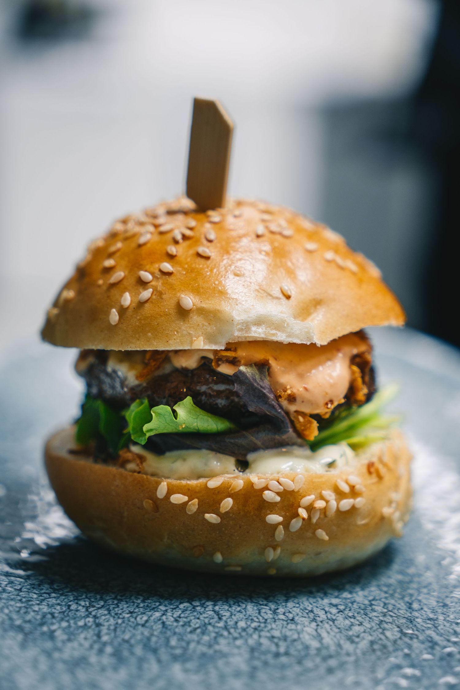 Hamburguesa gourmet emplatada servida en Restaurante ÓLEO. Fotografía de carta y menú para restaurantes de referencia en Málaga.