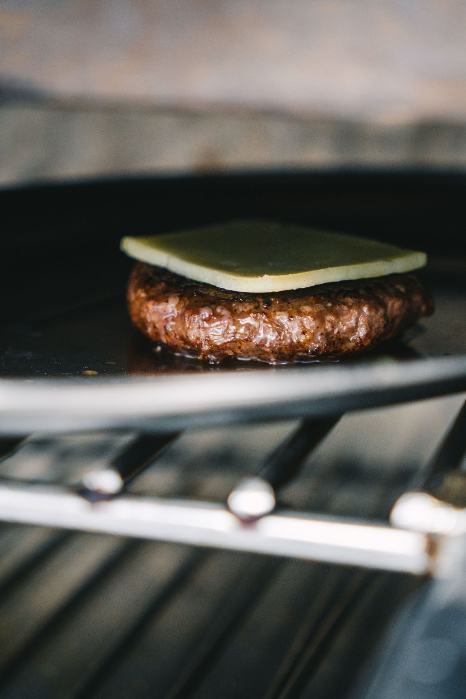 Carne de hamburguesa a la parrilla en las cocinas del Restaurante ÓLEO. Fotografía gastronómica profesional en Málaga.