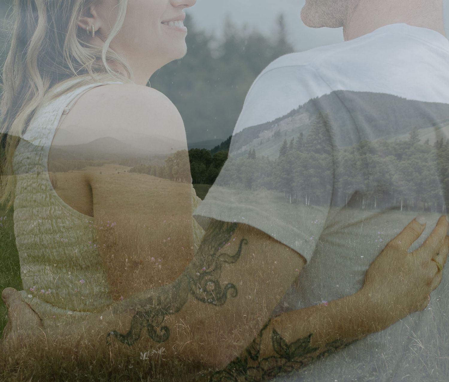 Double exposure photo of a couple embracing in a field with mountain landscape.