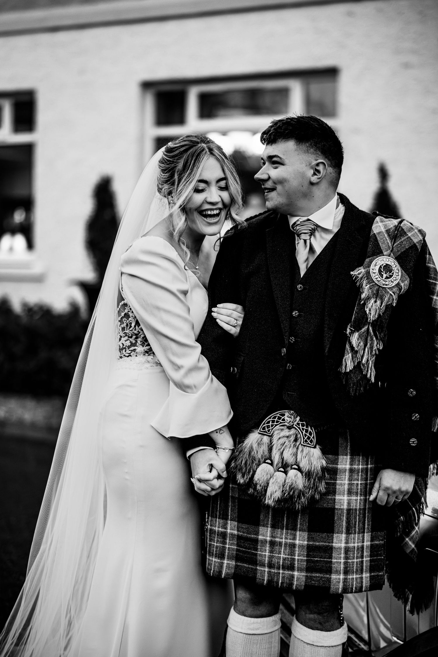 Wedding party wearing traditional Scottish kilts sharing laughs together. Drumossie Hotel Inverness Wedding Photography