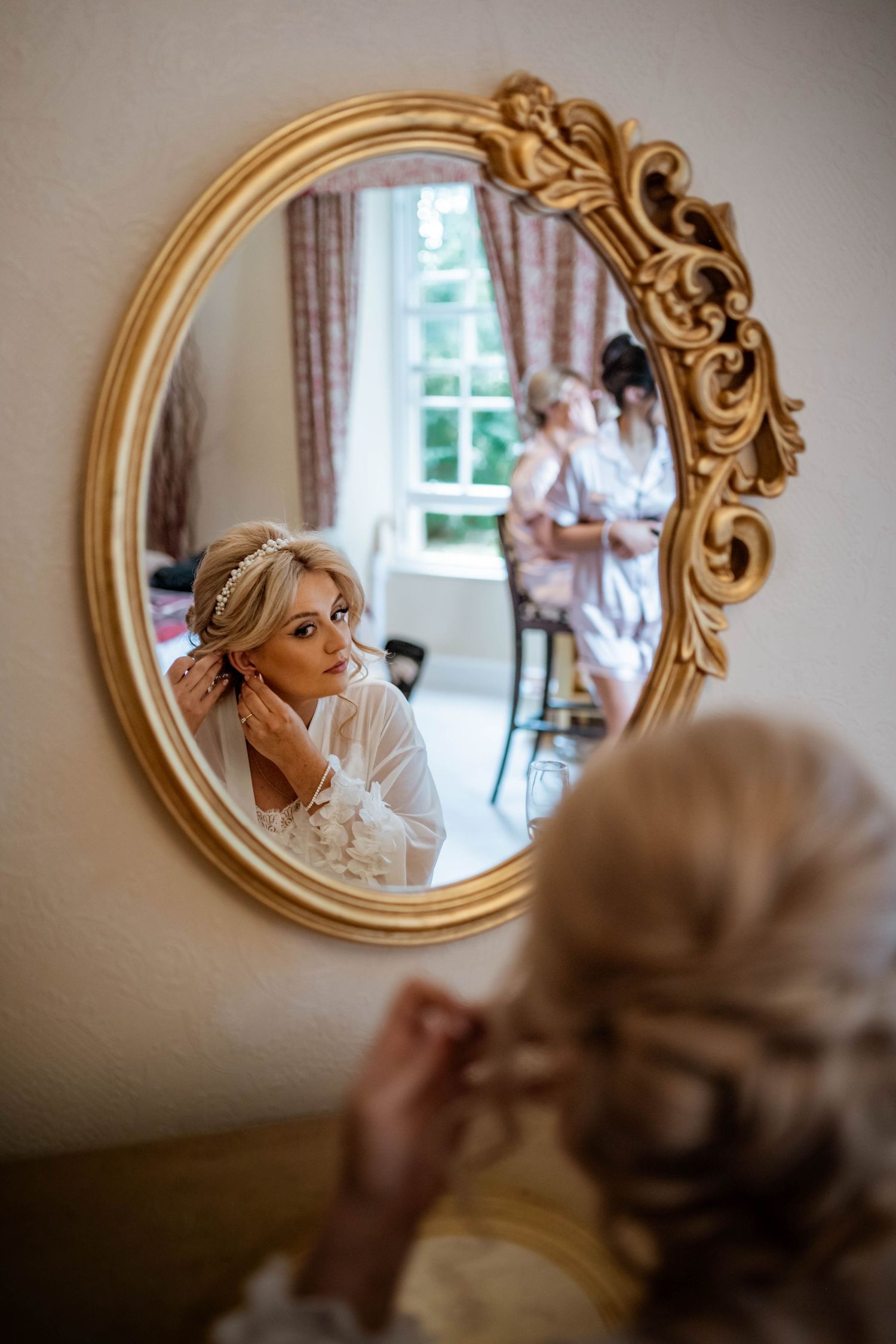 Reflection in ornate gold mirror captures bridal preparation moment. Muthu Newton Hotel Nairn Wedding Photography