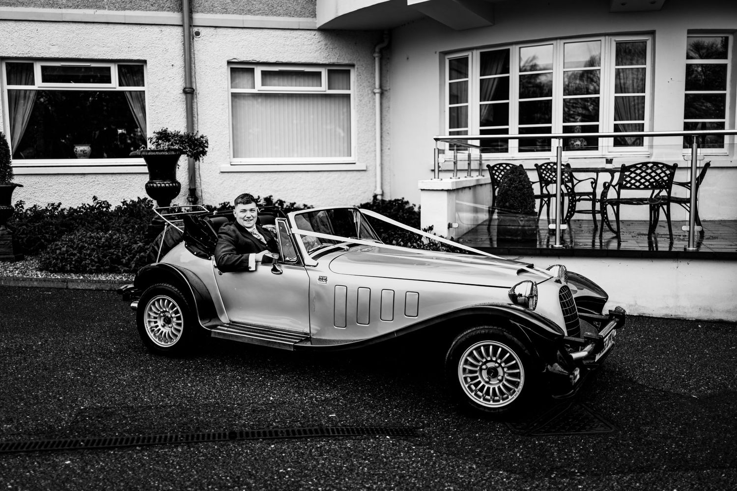 Vintage wedding cars lined up in black and white photography.