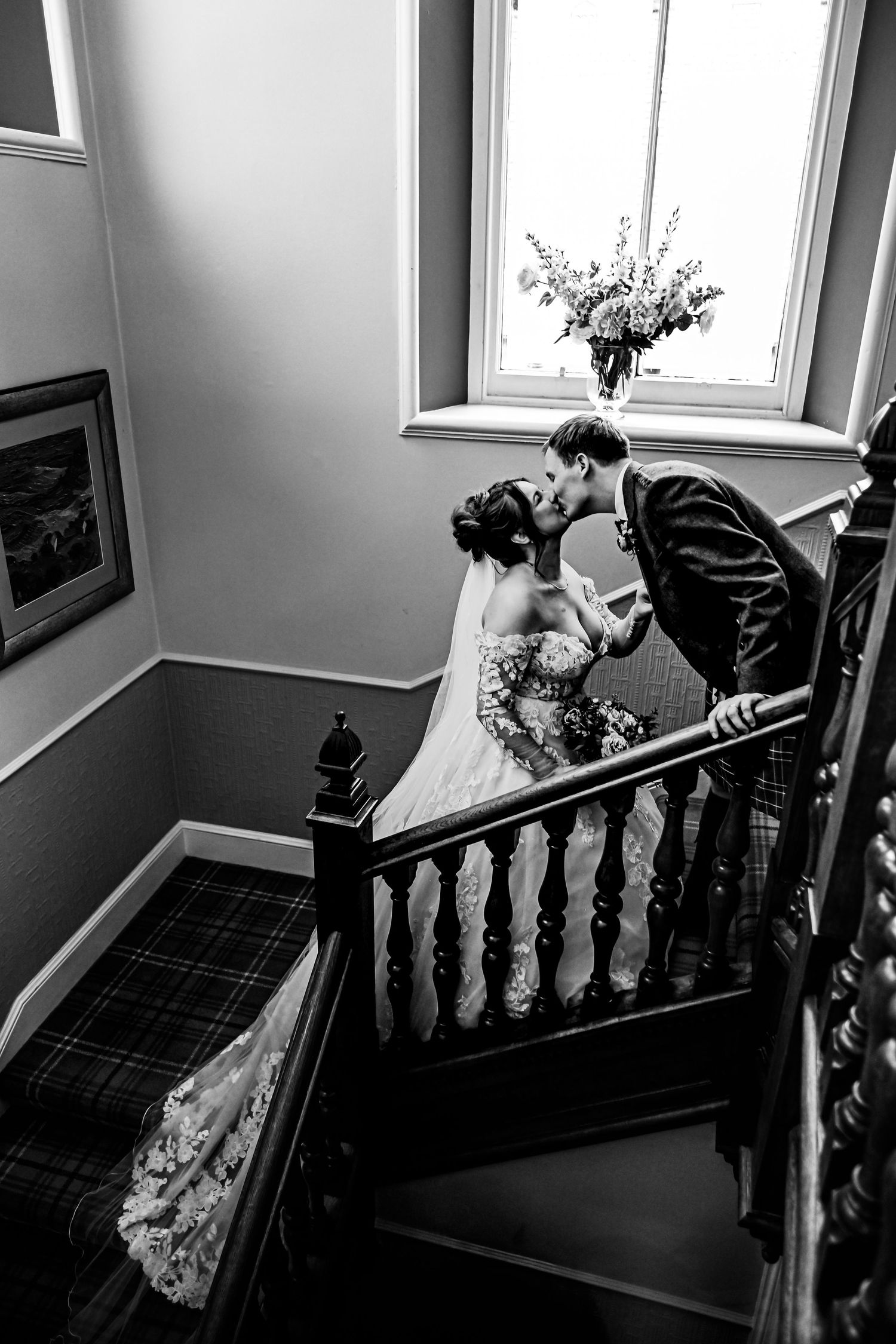 Black and white staircase wedding photos in elegant indoor setting with natural window light. LochNessCountryHouse Hotel Wedding photography