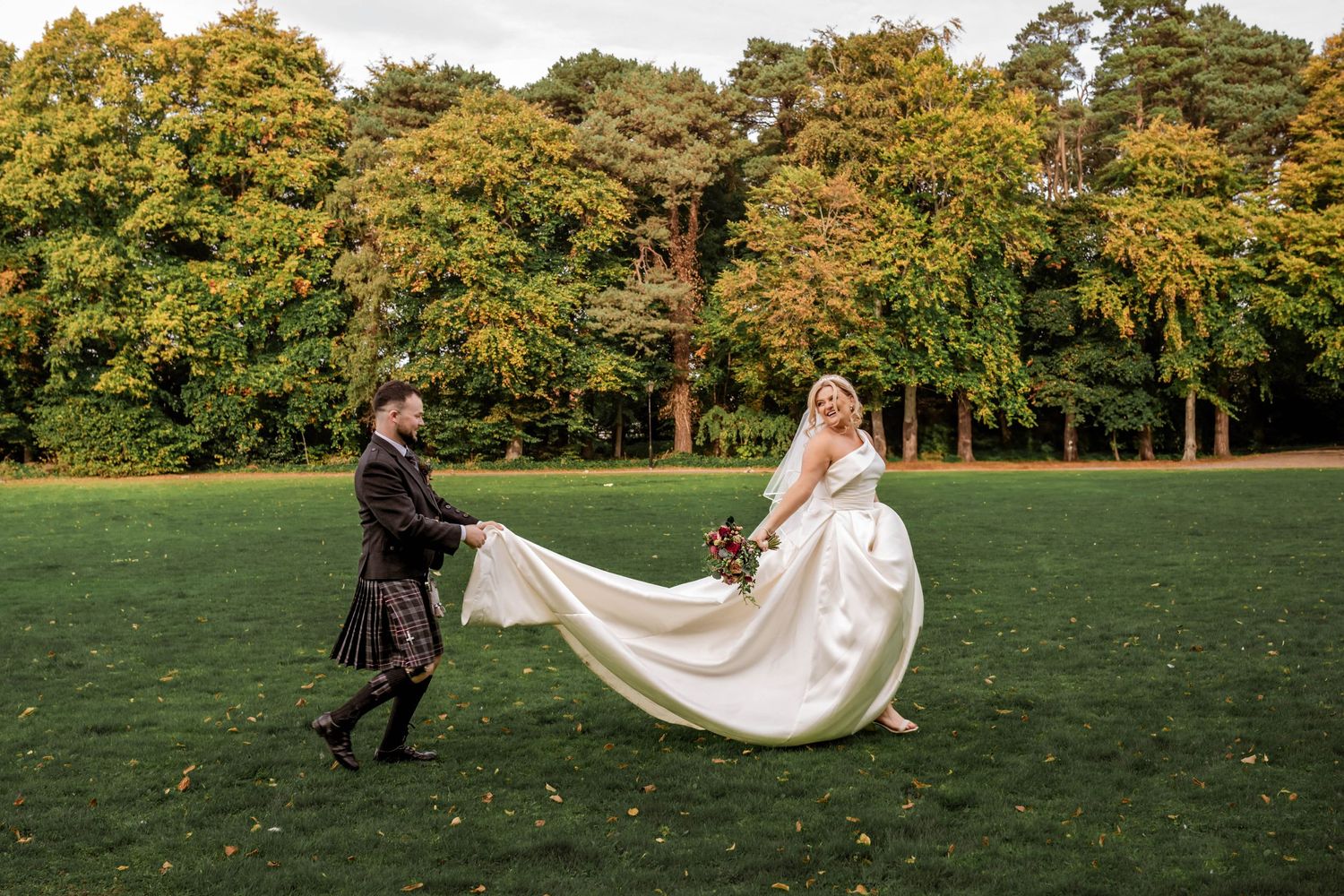 Wedding couple running across an autumn field with flowing dress and kilt. Muthu Newton Hotel Nairn Wedding photography