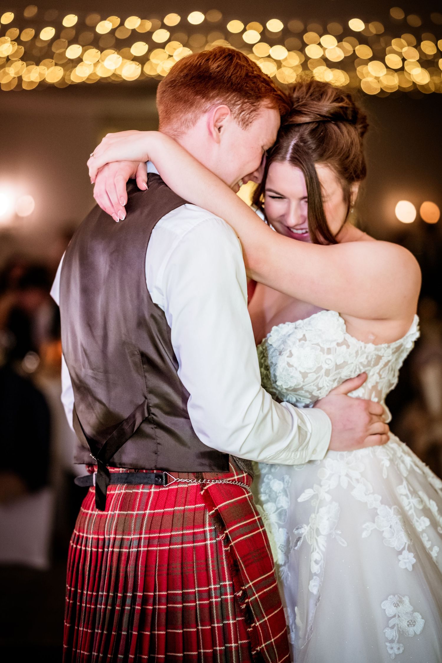 Close-up details of traditional Scottish wedding attire with red tartan kilt during a dance. LochNess Country House Hotel Wedding Photograph