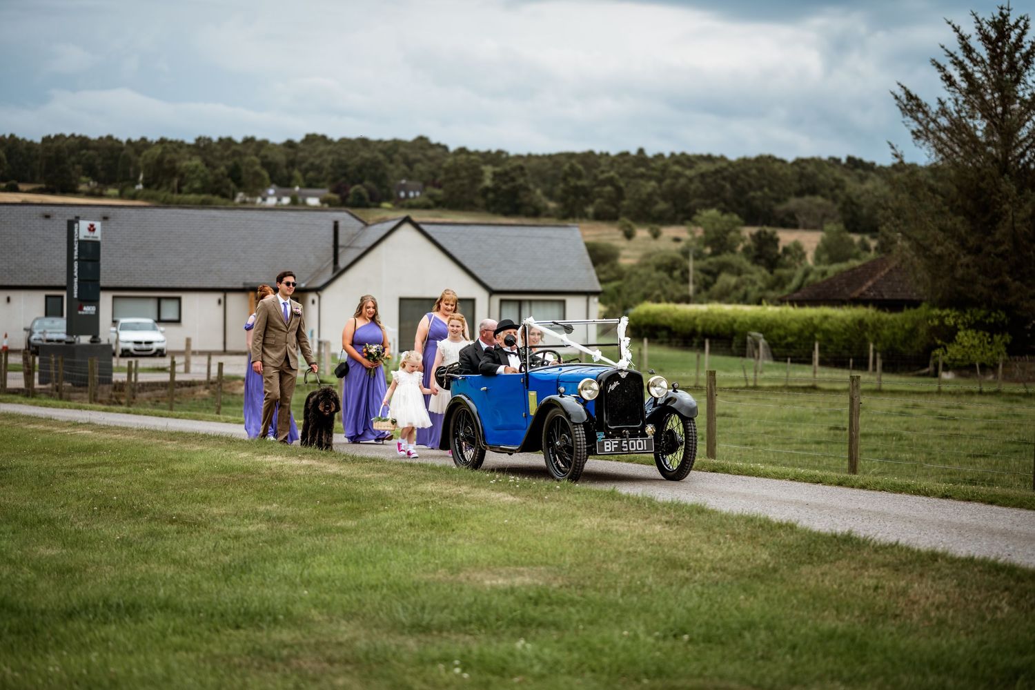 A scenic outdoor wedding venue setup with white chairs and decorations against a mountainous landscape. Scottish Highlands Farm Wedding