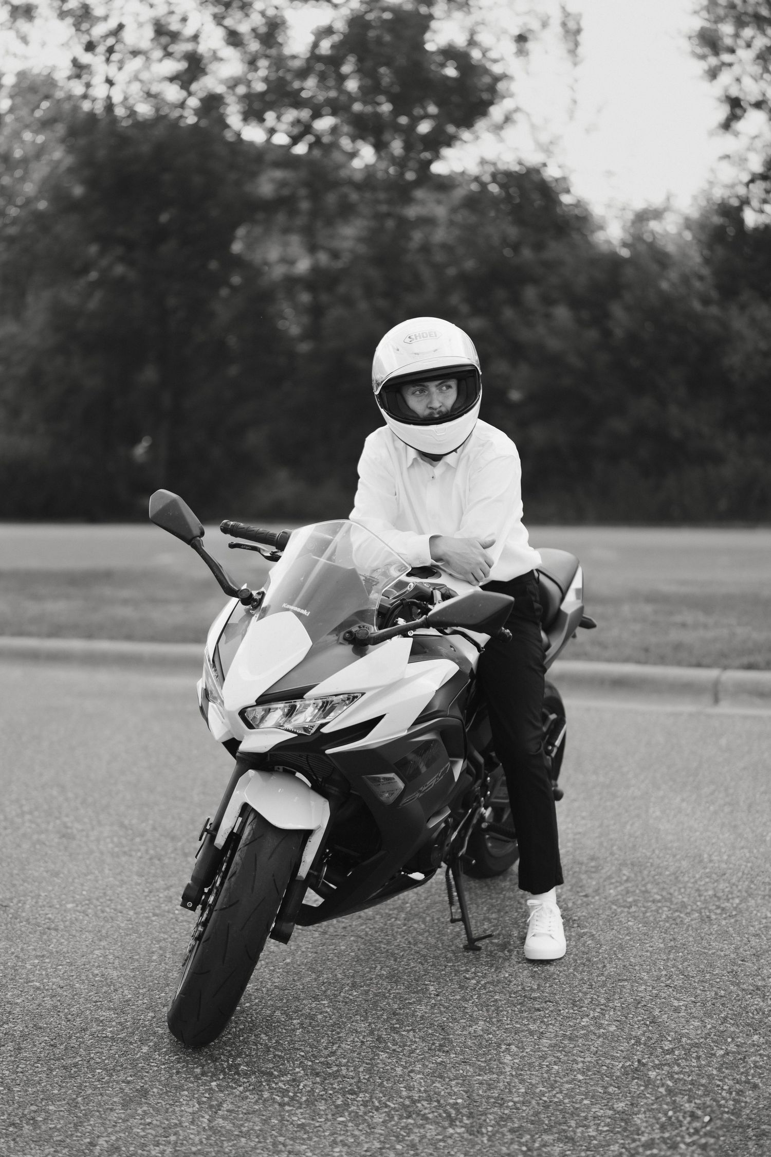 Black and white photo of a person in white helmet posing on a sport motorcycle in Lebanon Hills Regional Park.