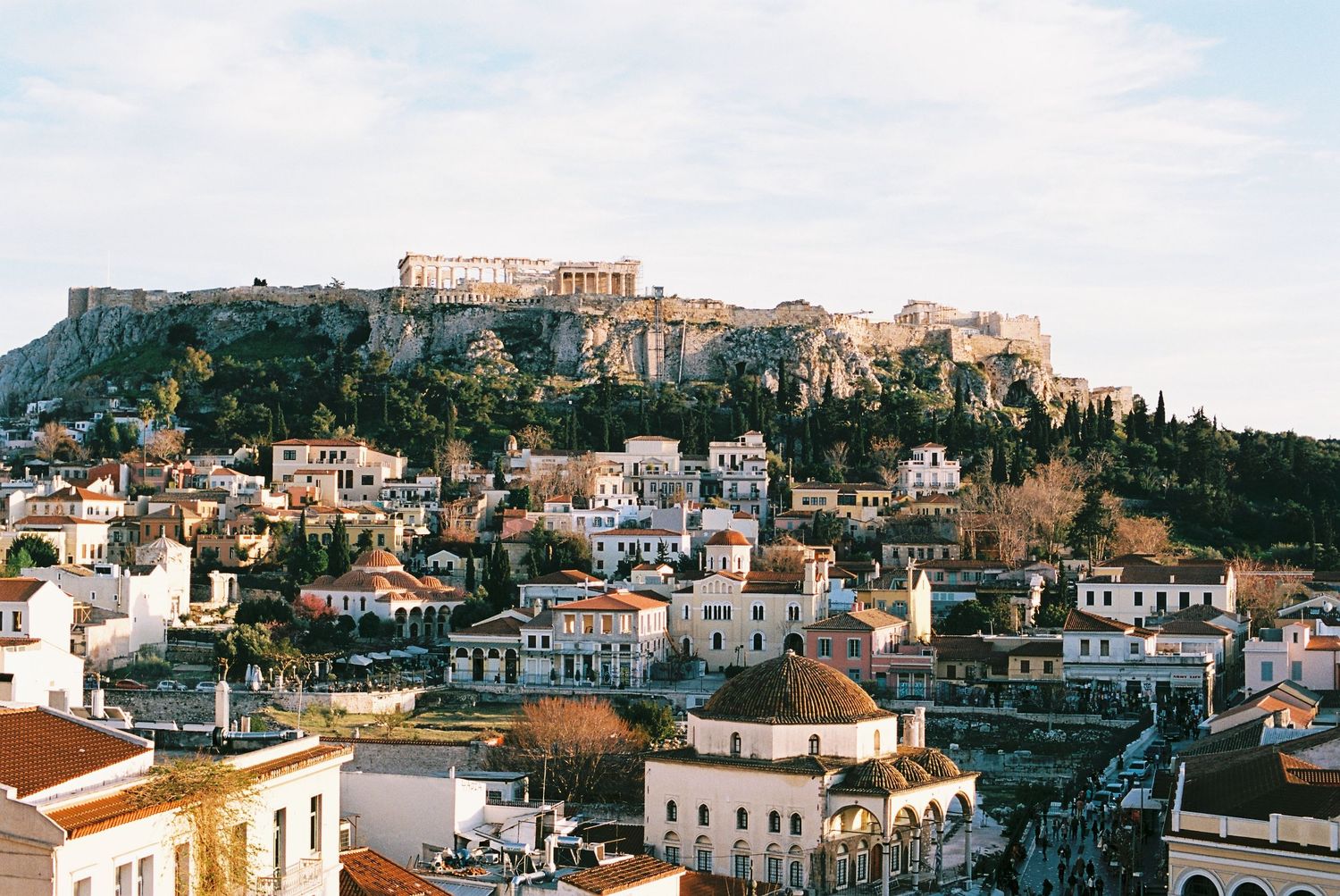 Panoramic view of Athens cityscape with the ancient Acropolis and Parthenon perched on the hilltop.