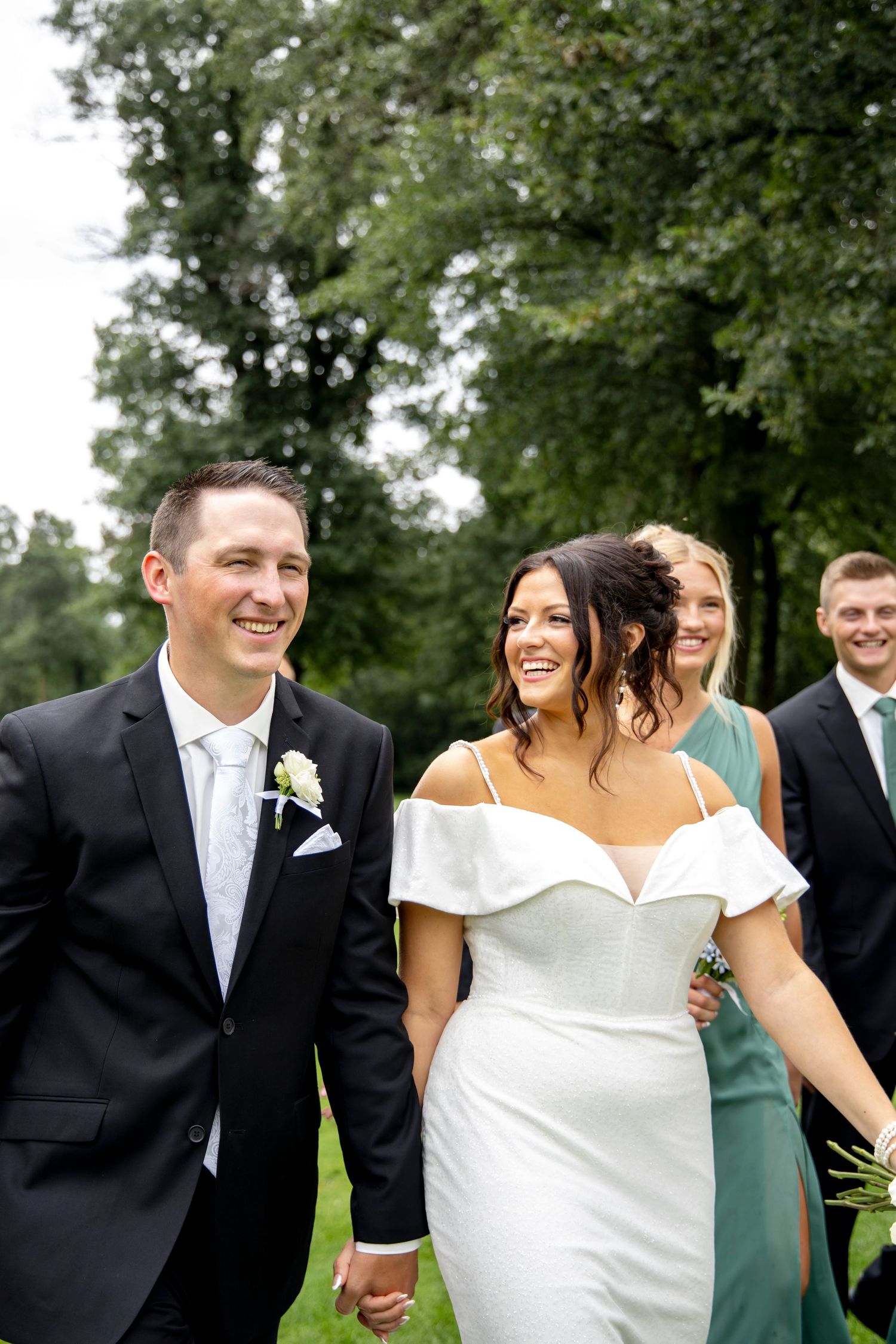 Wedding party shares candid laughing moments during outdoor photo session.