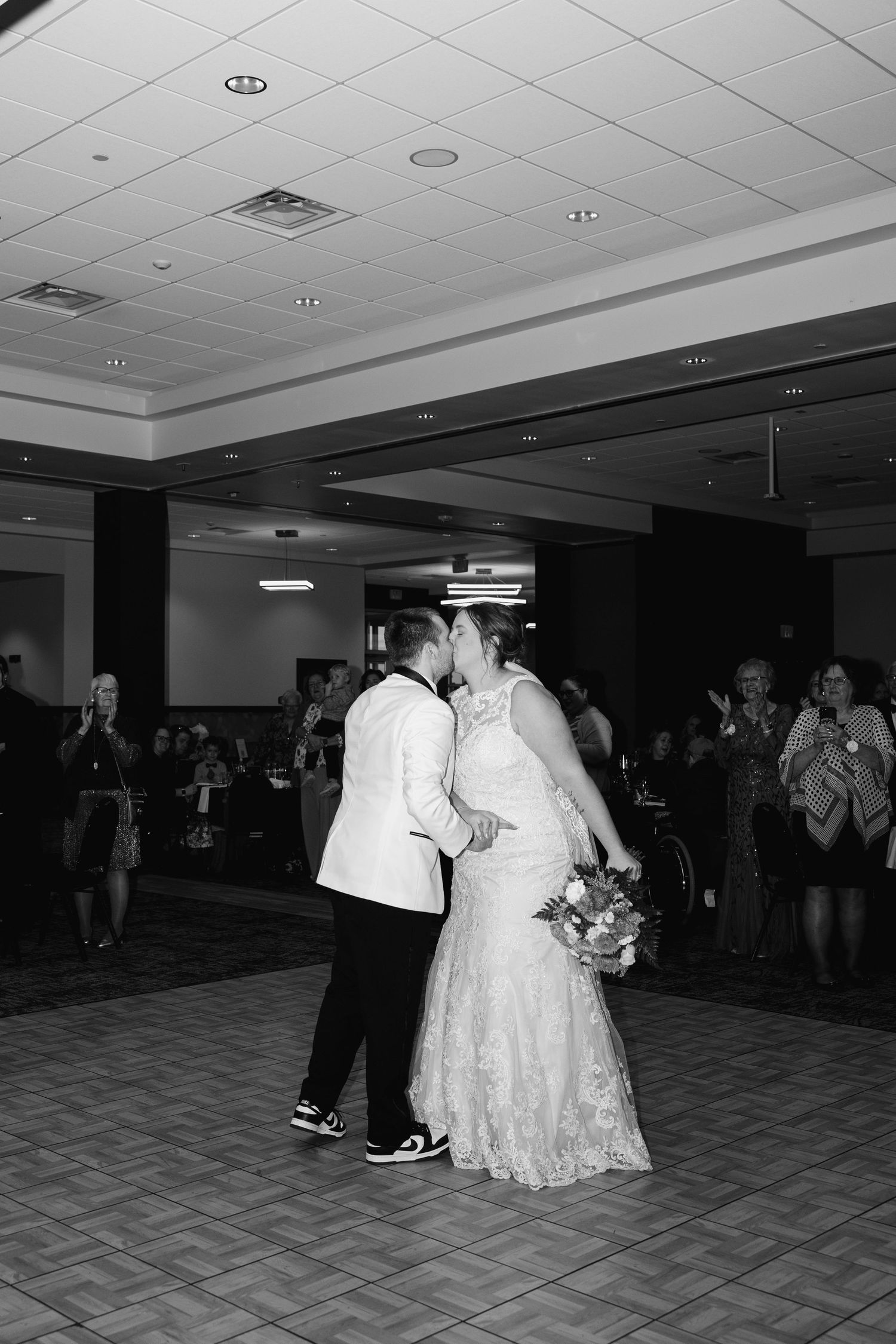 Couples dance together at a wedding reception in formal attire.