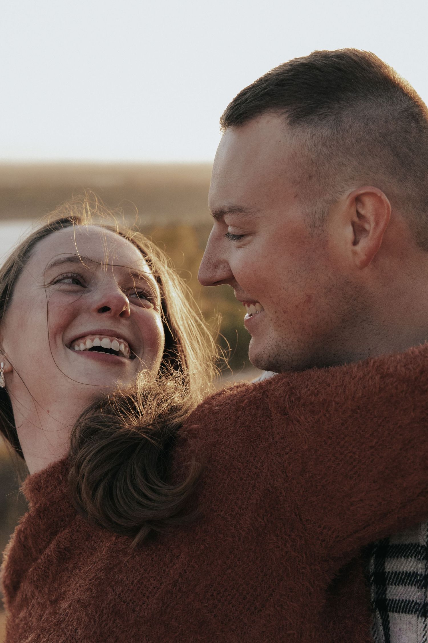 Intimate candid moment between couple during golden hour outdoors.